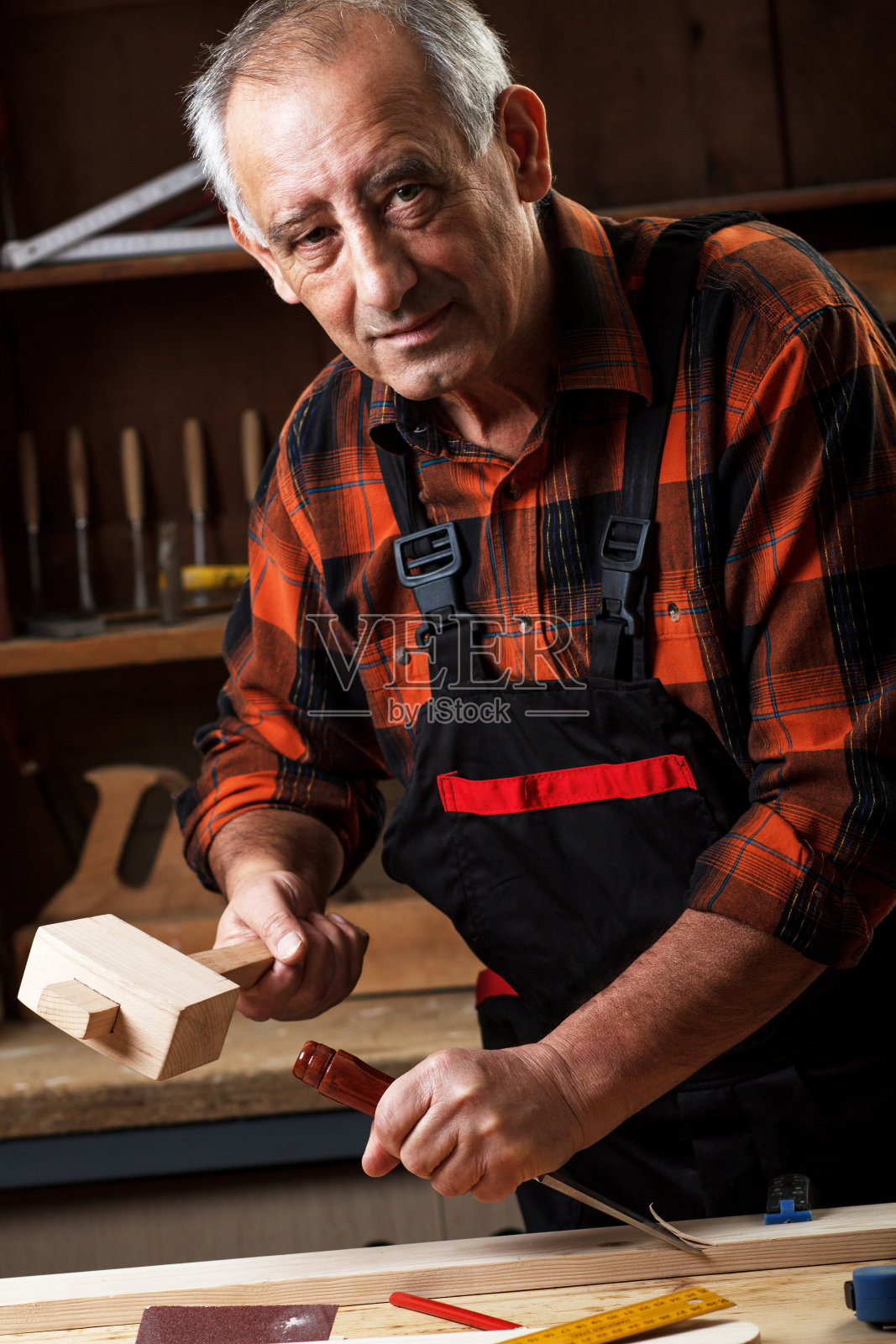 用工具工作的高级木匠。照片摄影图片