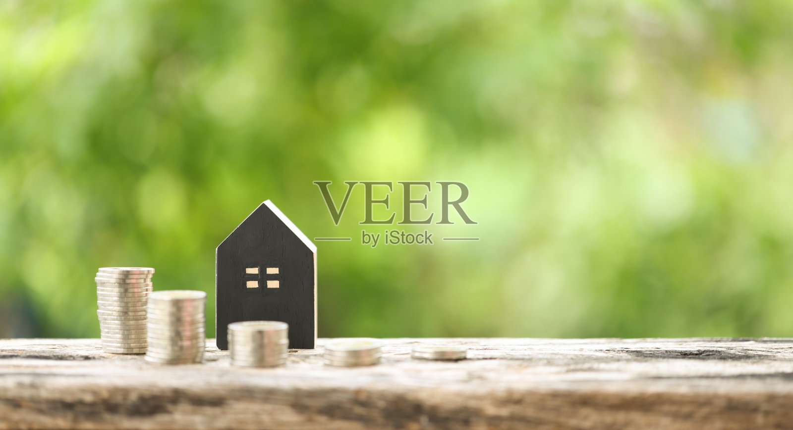 宁静自然背景下的住房贷款与钱币|金融、投资与房地产概念。硬币在宁静的自然背景。金融增长、房地产投资和储蓄。照片摄影图片