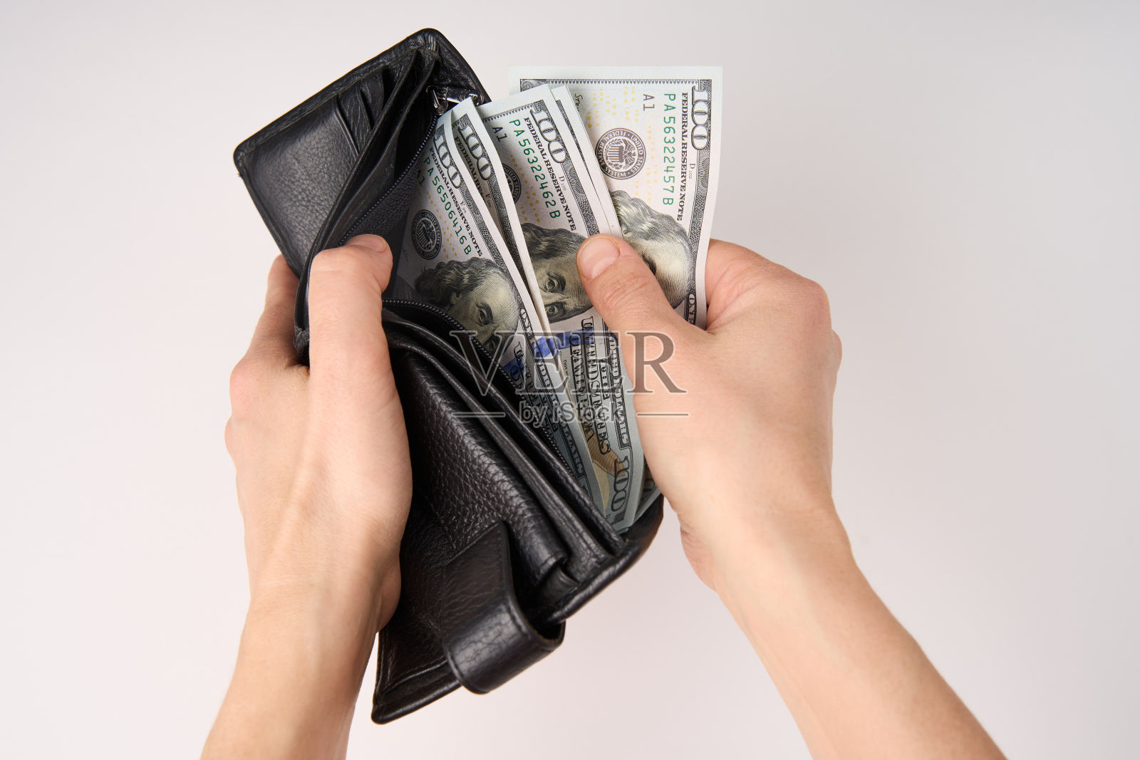 手拿钱包与美元的钱在白色背景照片摄影图片