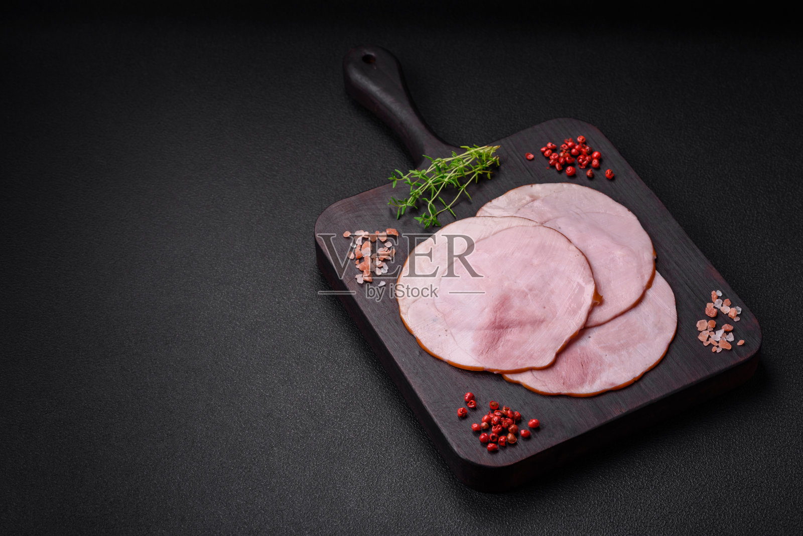 美味的新鲜火腿切成圆片,加入盐、香料和香草照片摄影图片