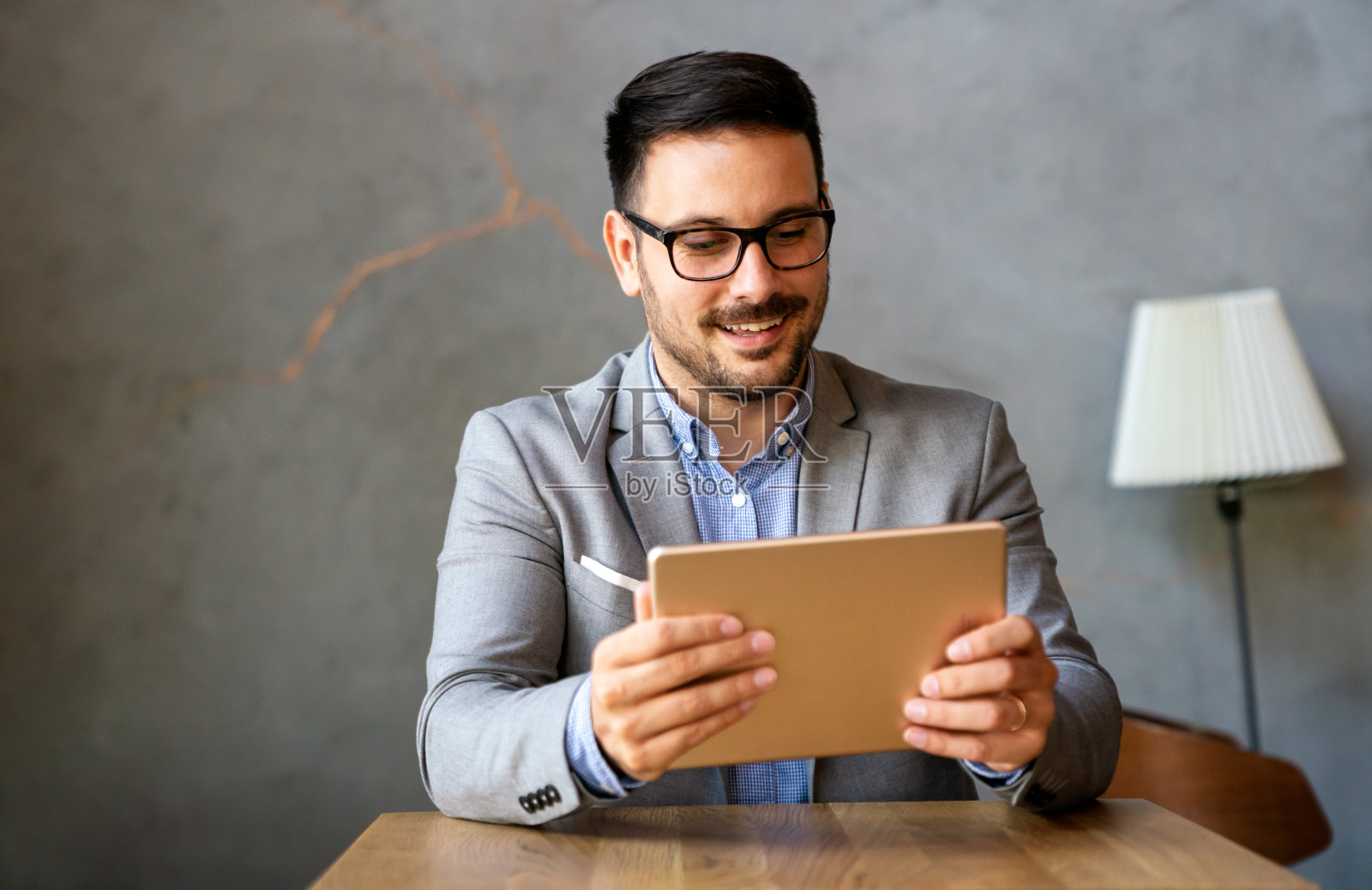 幸福成功的年轻商人肖像,领导者,首席执行官,经理使用数字平板电脑工作。照片摄影图片