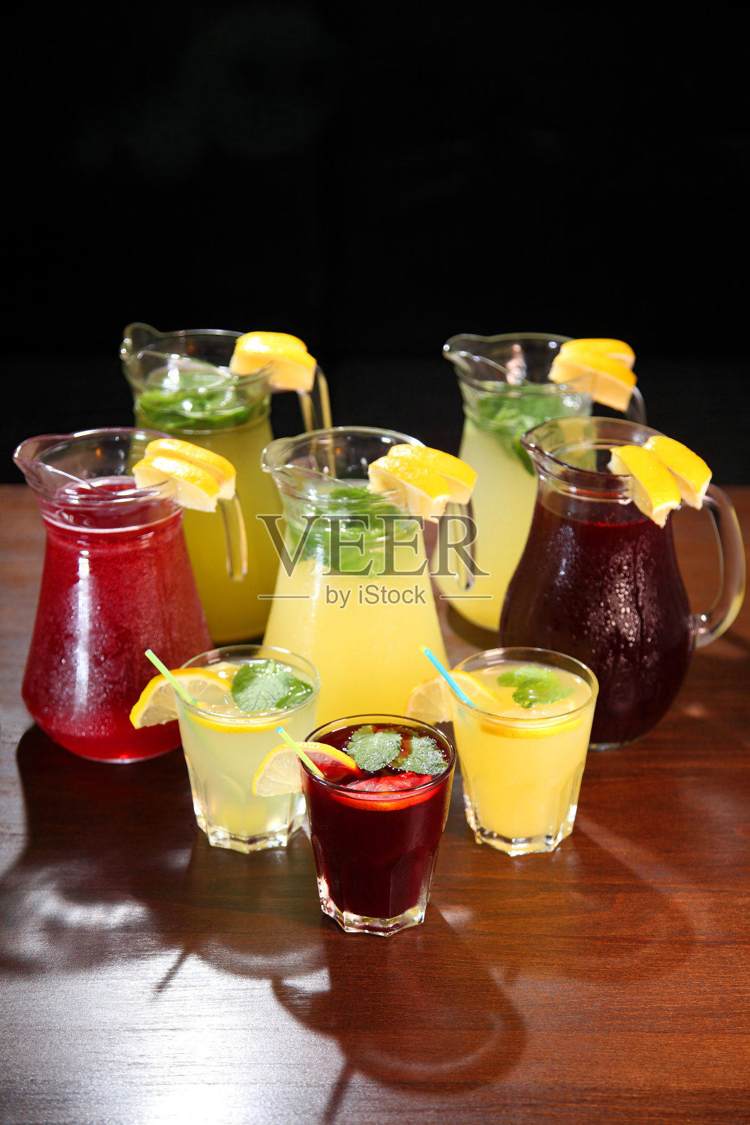 寒冷的柠檬水。草莓柠檬水。解渴提神的饮料。壶里有柠檬水,室内桌上有柠檬和薄荷。照片摄影图片