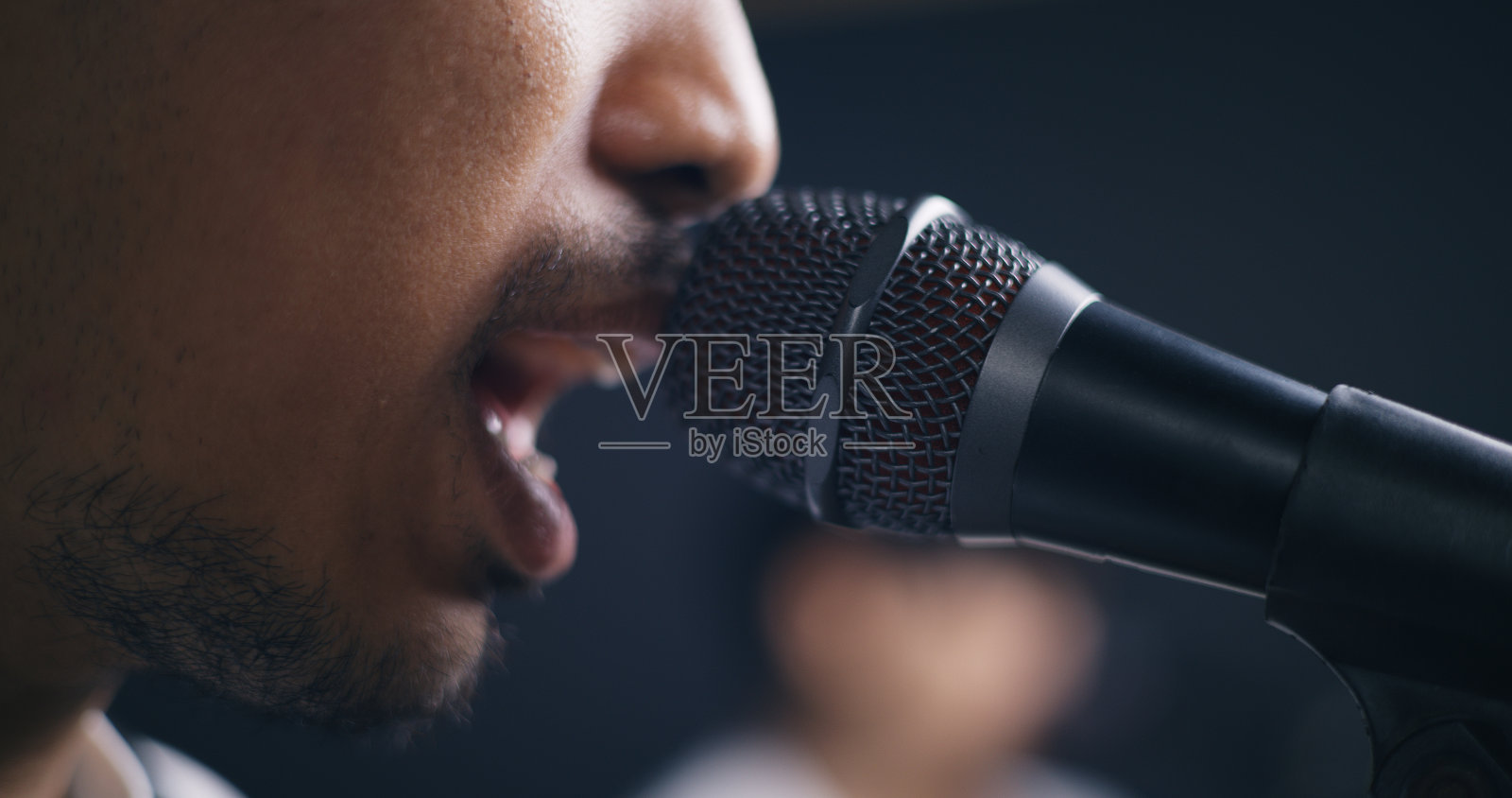 年轻的亚洲男性音乐家穿着休闲服,在歌手唱歌的同时弹着电吉他照片摄影图片