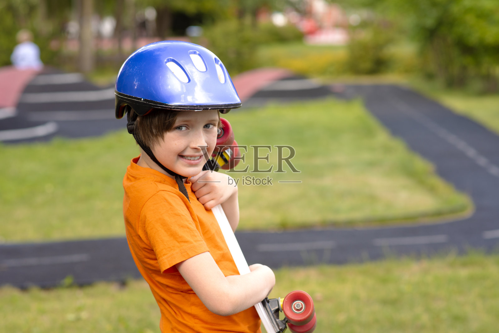 戴着防护头盔的快乐男生手持滑板照片摄影图片