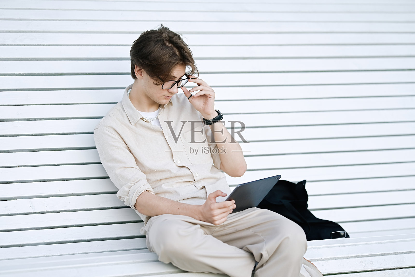 年轻人坐在长凳上使用笔记本电脑照片摄影图片