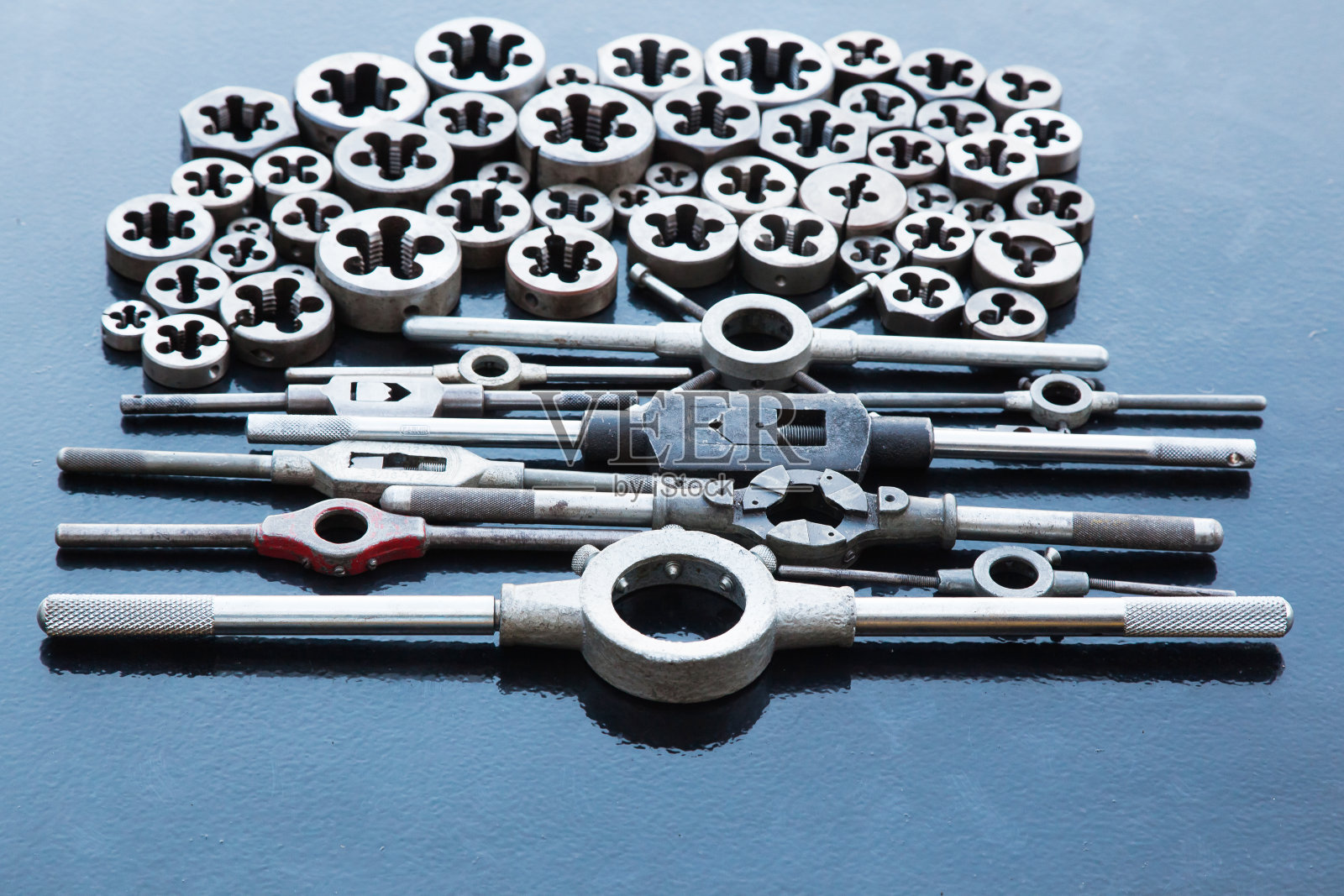 许多模具和持有人为他们不同的尺寸螺纹在金属,在黑色背景。照片摄影图片