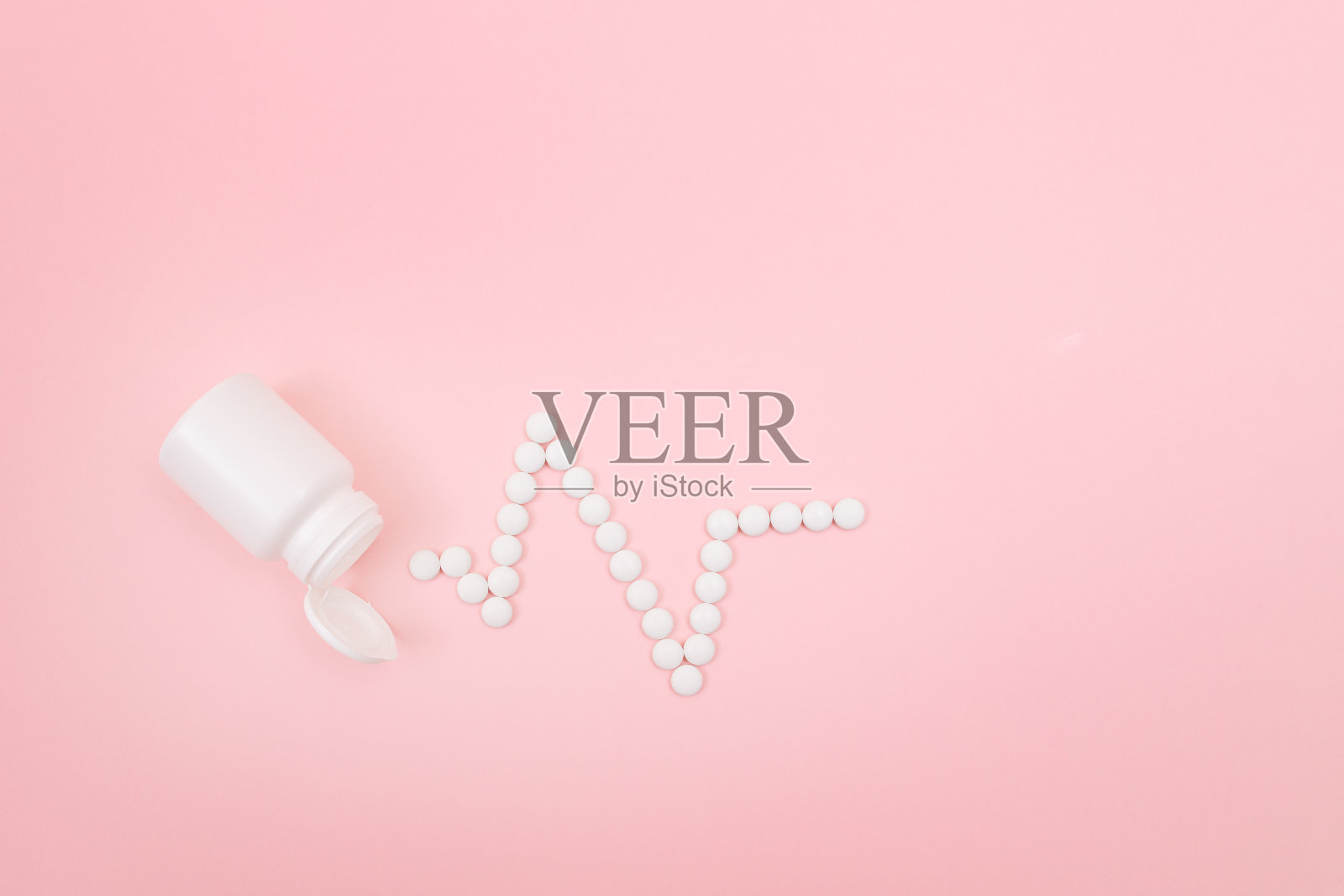 心跳的节奏。心电图线由白色药片制成。制药行业照片摄影图片