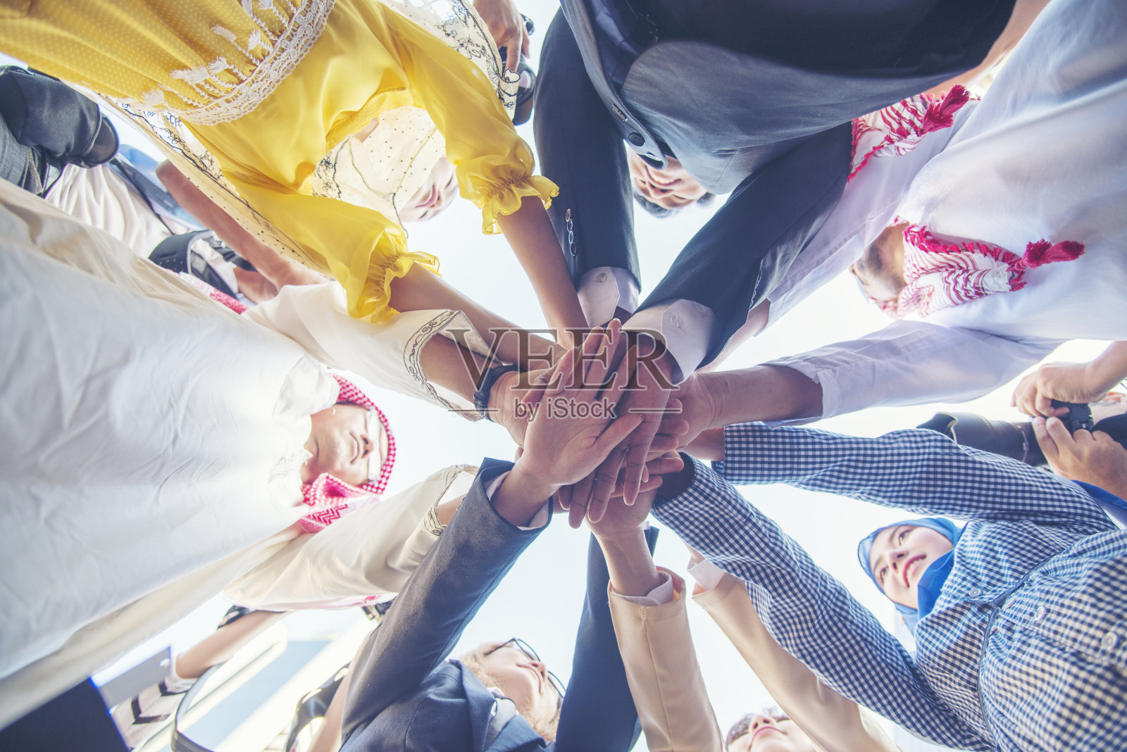 快乐多元多民族伙伴携手共进。多种族微笑人群的团队合作,携手共进。多元化的人加入授权伙伴关系团队志愿者联系照片摄影图片