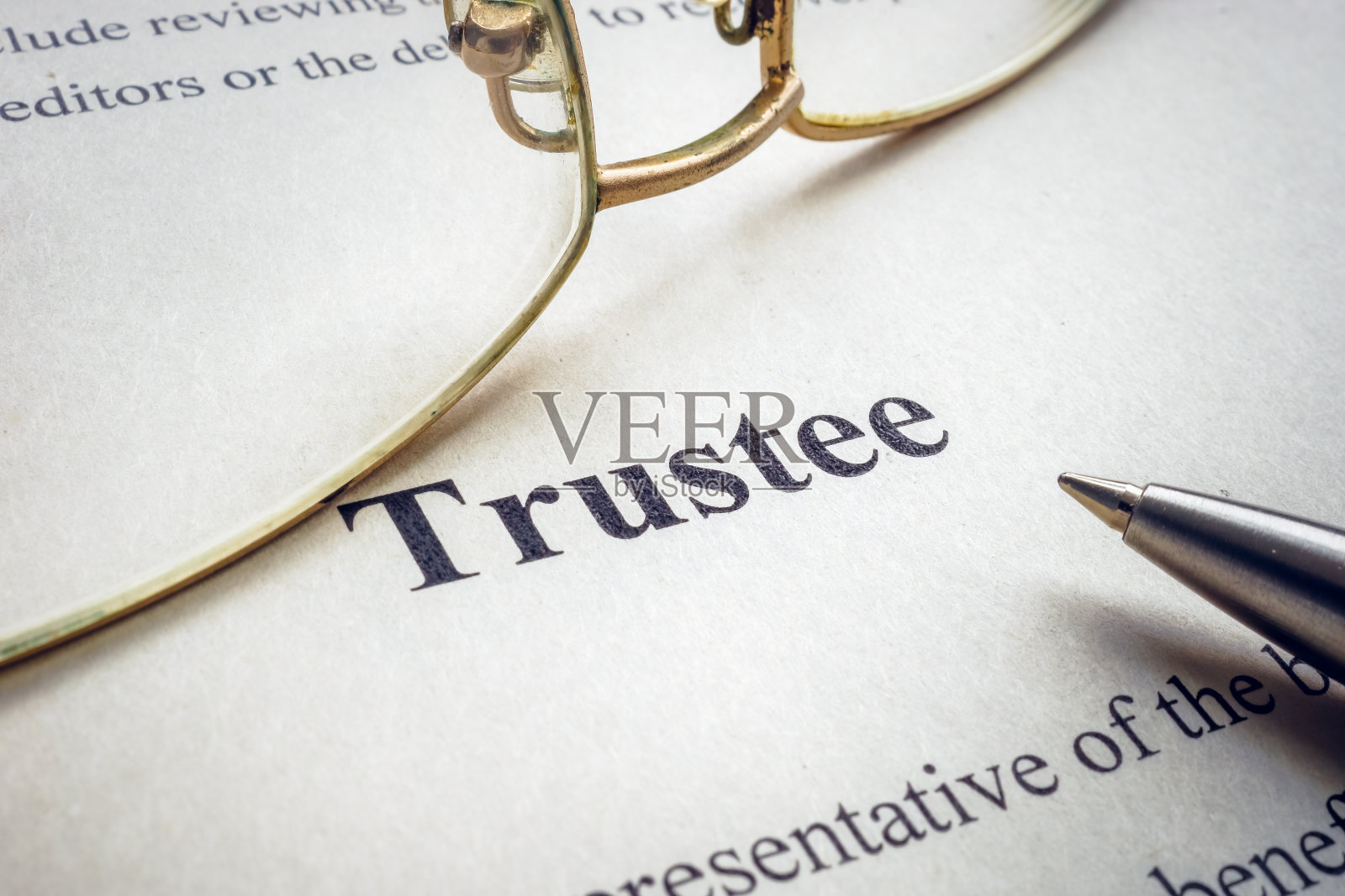 文字受托人附近的眼镜和笔。照片摄影图片