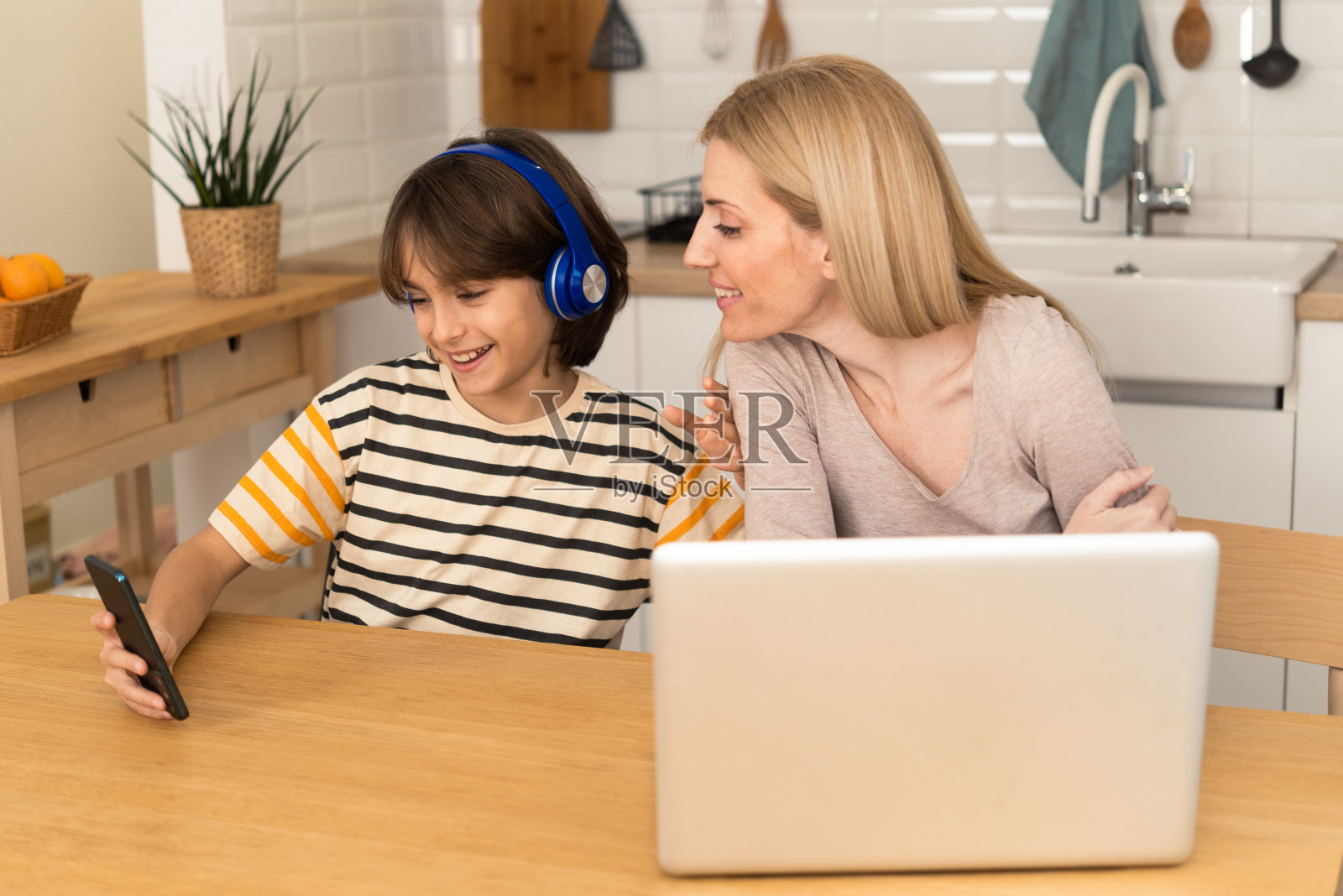 男孩上网,而他妈妈在家工作照片摄影图片