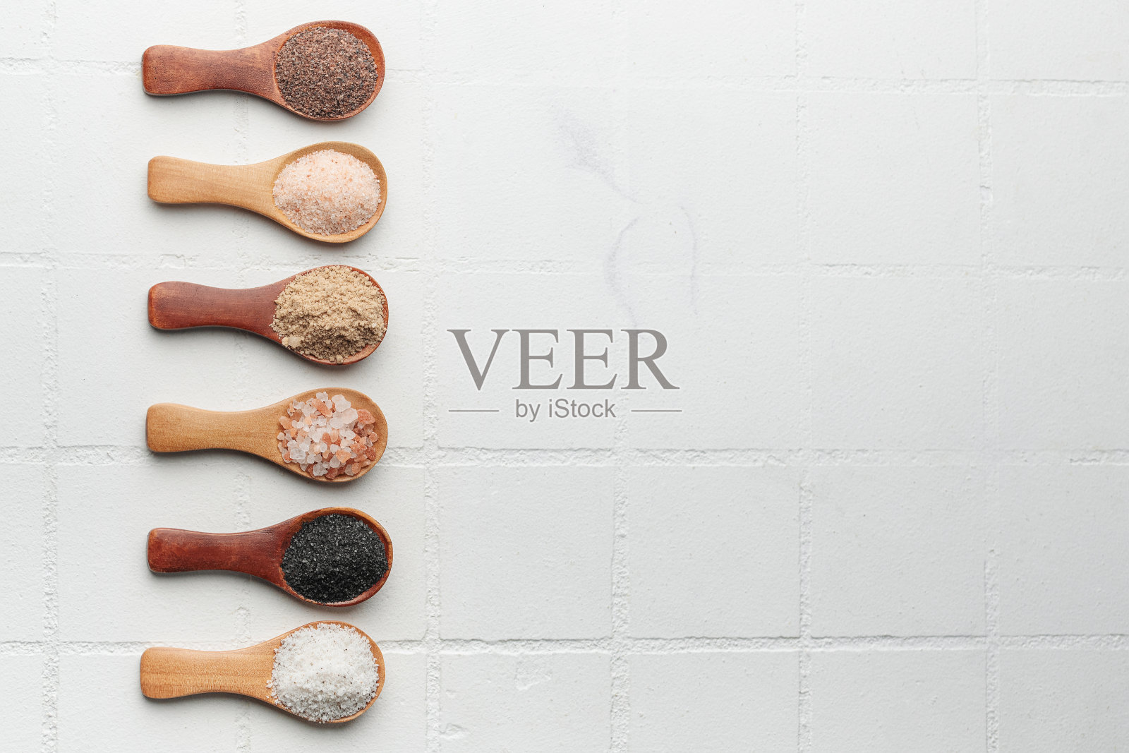 勺子里放各种特制盐照片摄影图片