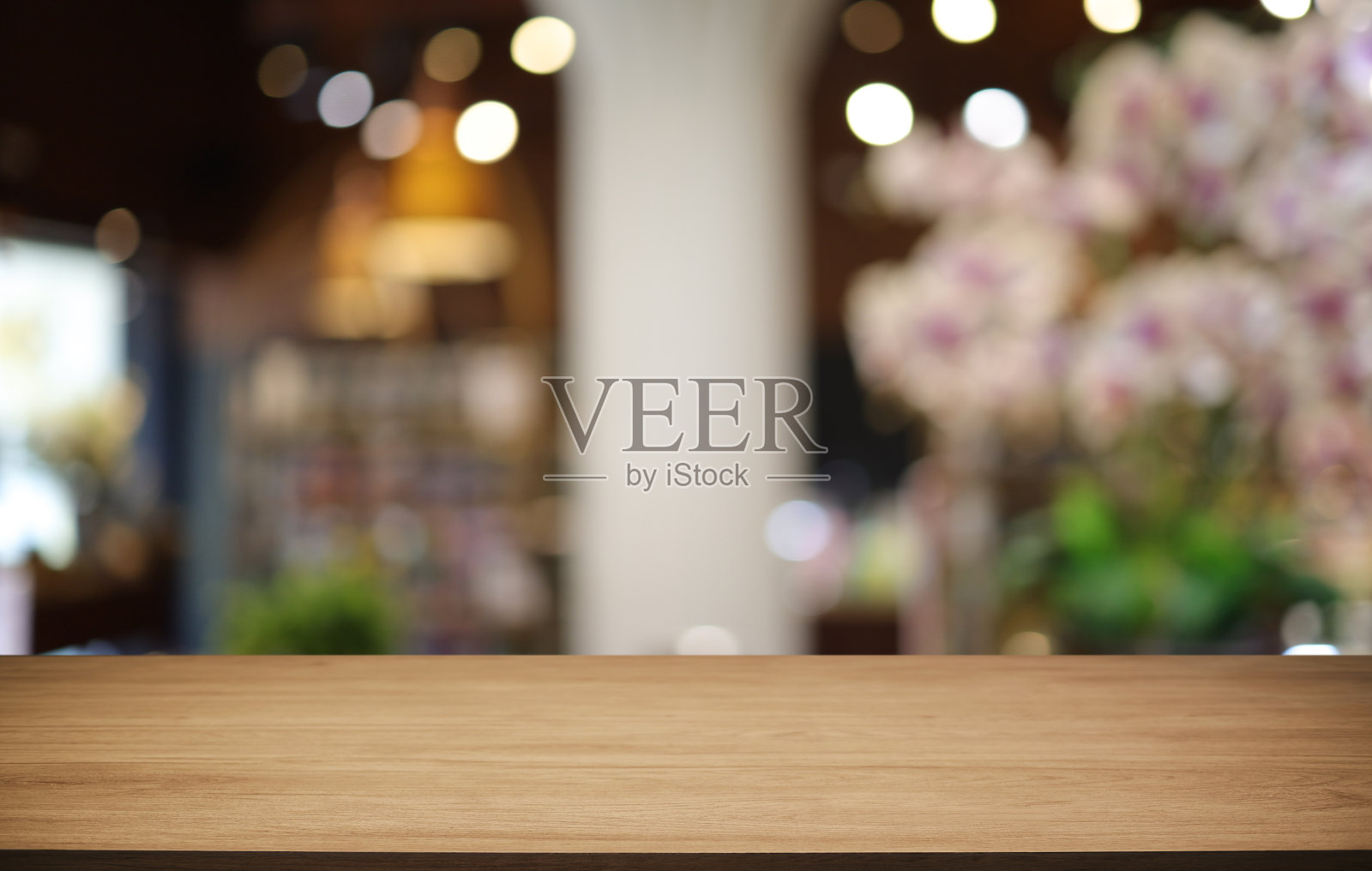 咖啡厅抽象模糊背景前的空木桌。可以用来展示或蒙太奇您的产品。产品展示的模型照片摄影图片