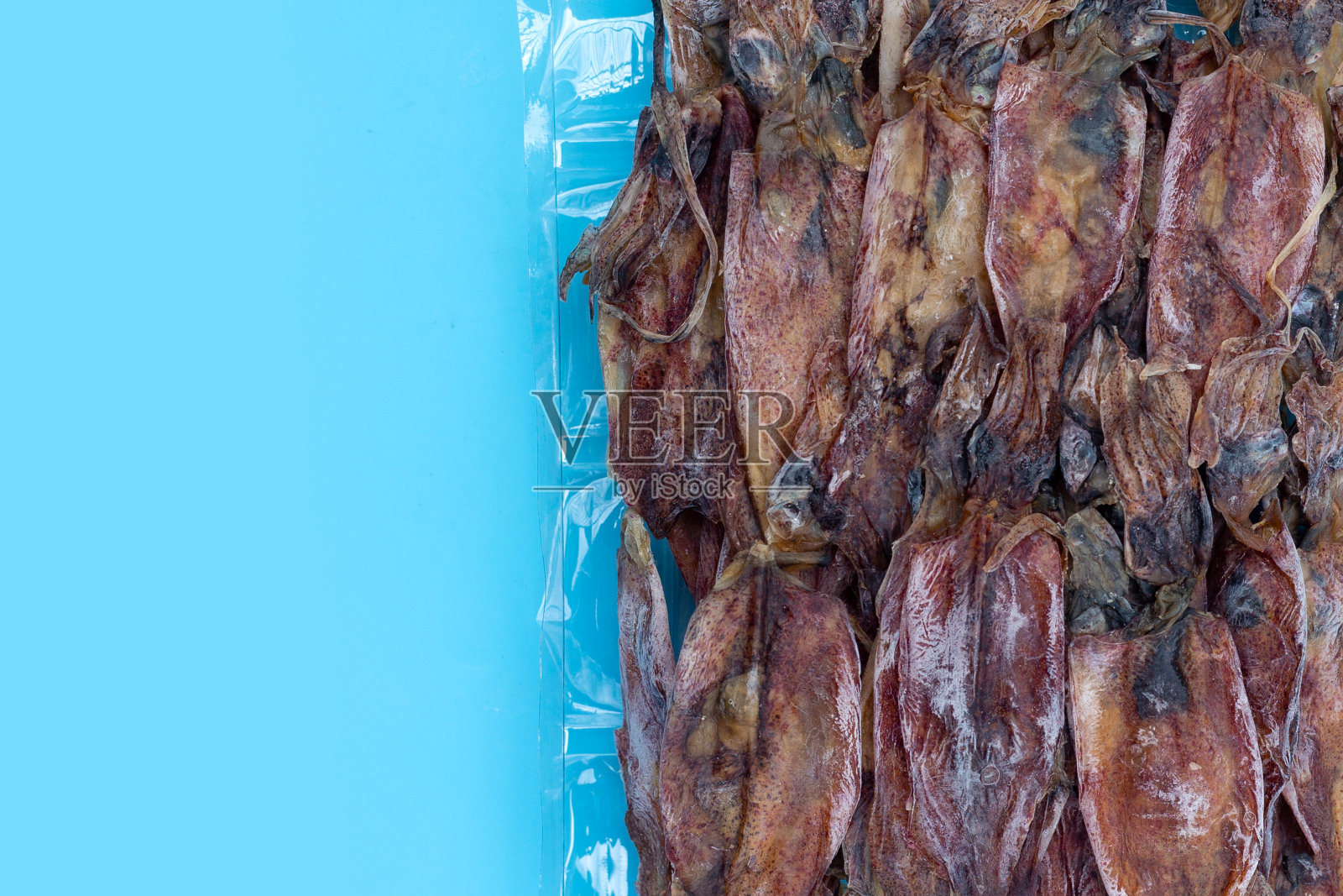 干鱿鱼在蓝色背景。照片摄影图片