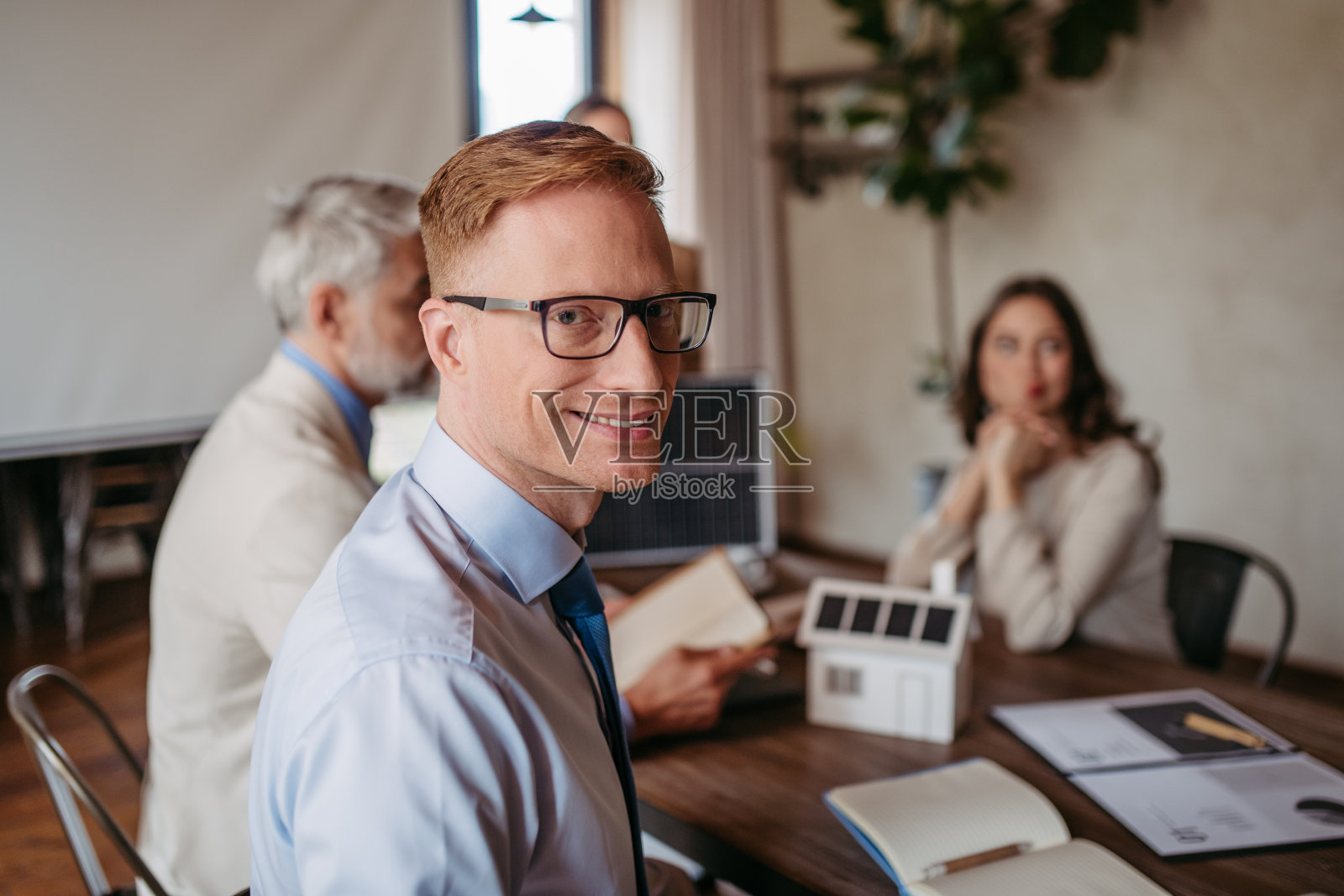 年轻商人在办公室开会时的肖像。照片摄影图片