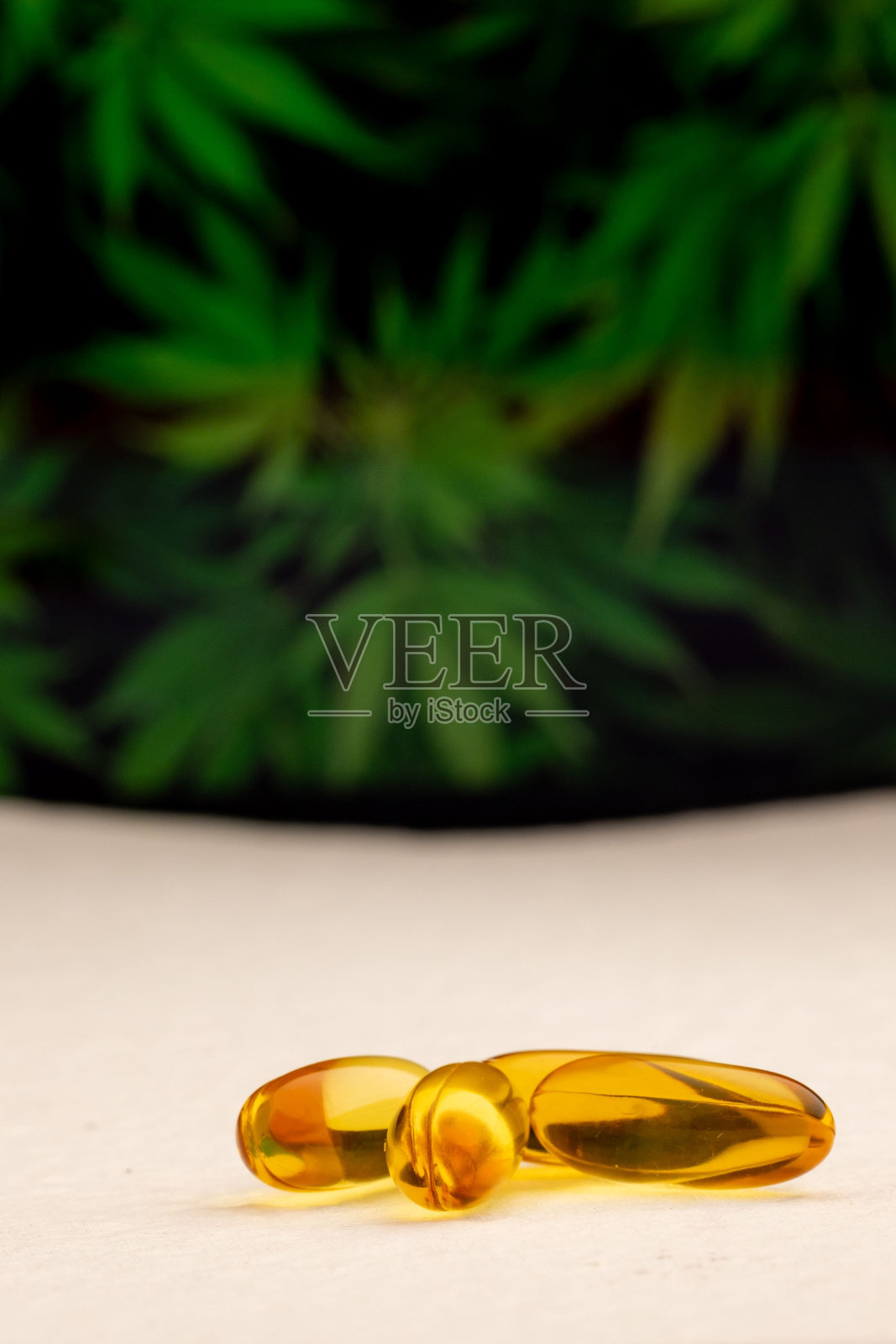 桌面上的橙色油胶囊的特写镜头,背景模糊照片摄影图片