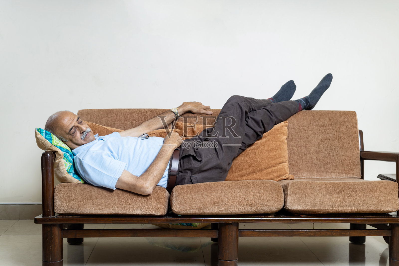 印度老人在客厅的沙发上休息。老人坐在沙发上休息照片摄影图片