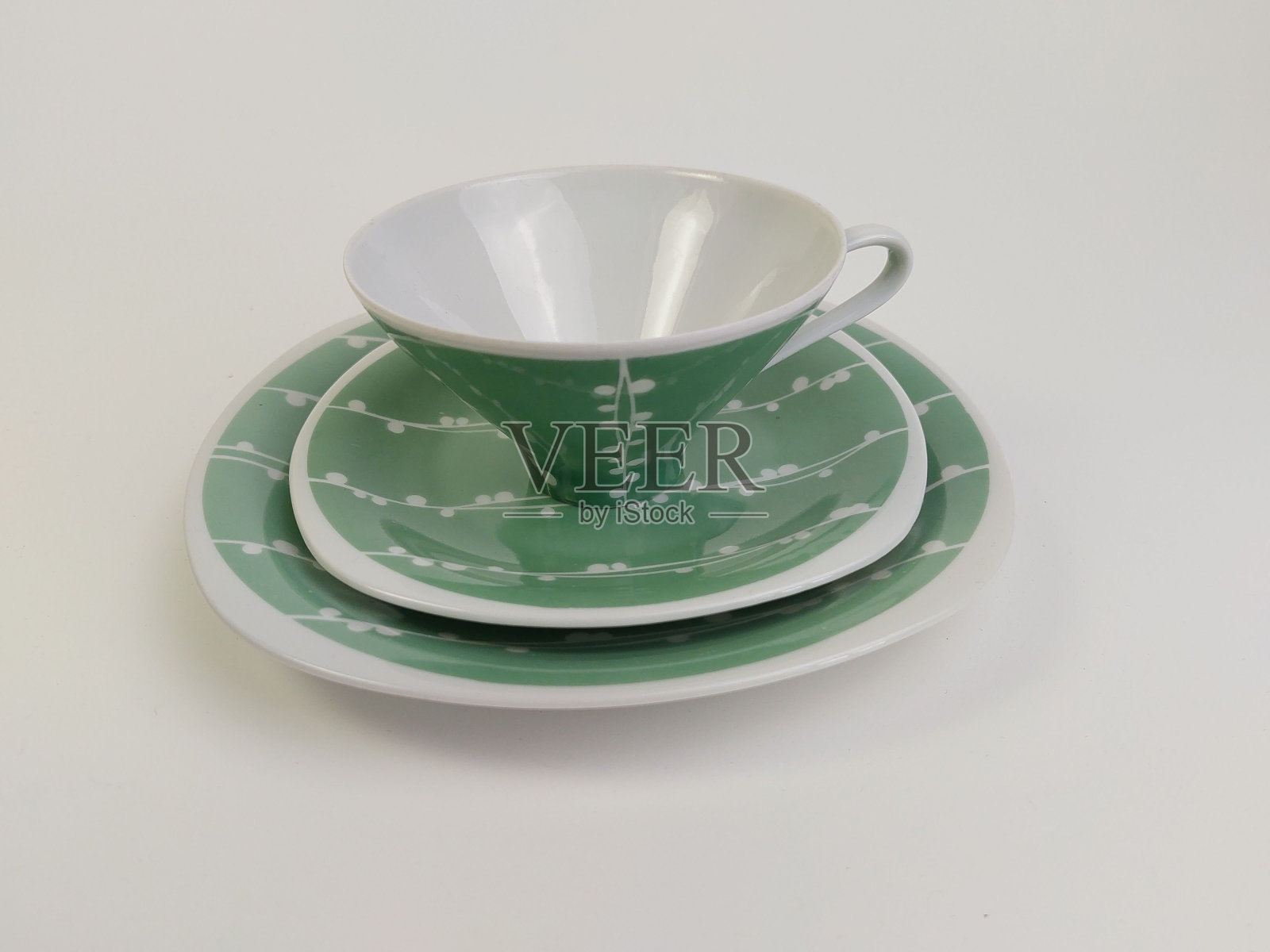 一套陶瓷杯子和碟子排列在白色的表面上照片摄影图片