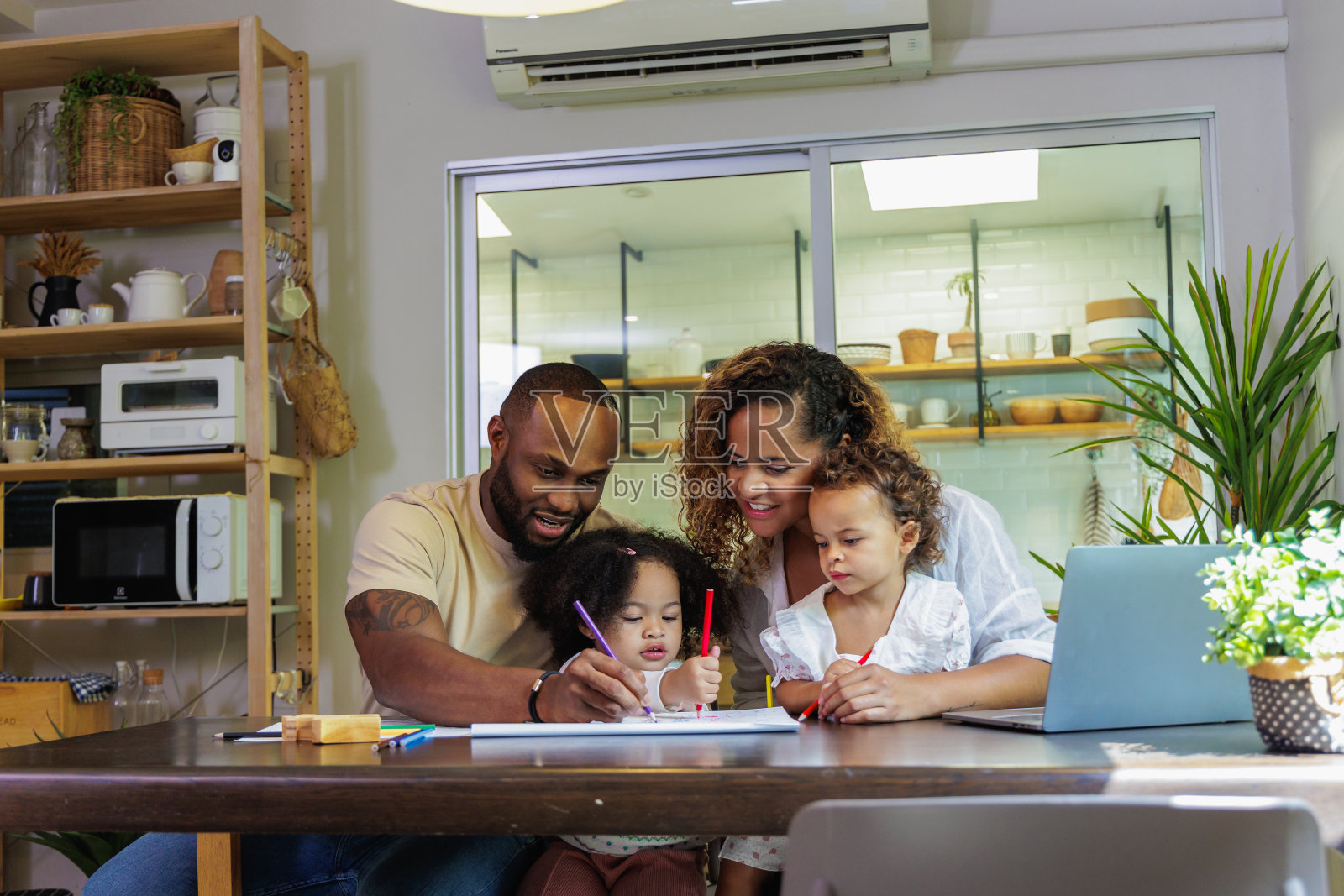 非洲父亲和母亲带着孩子画画照片摄影图片
