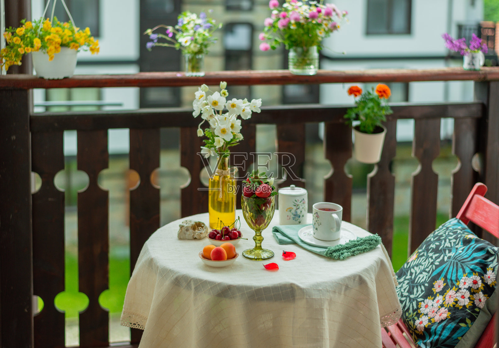 在乡间别墅的露台上喝着鲜花和水果的早茶。照片摄影图片