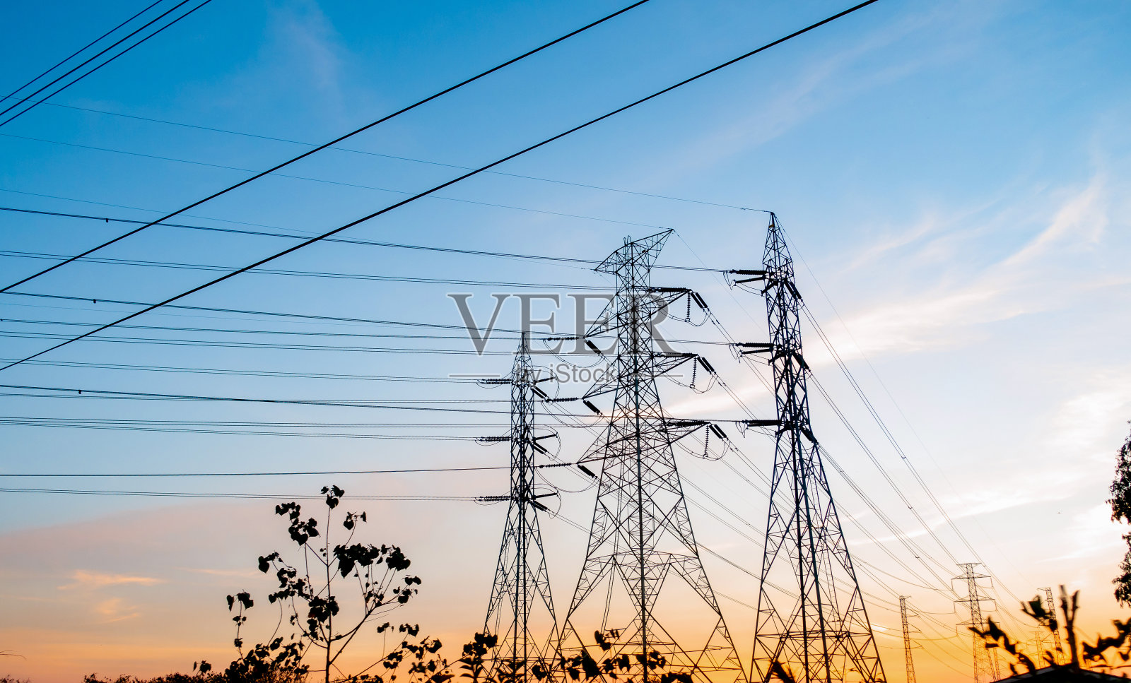 天空日落背景上高压电杆的剪影。照片摄影图片