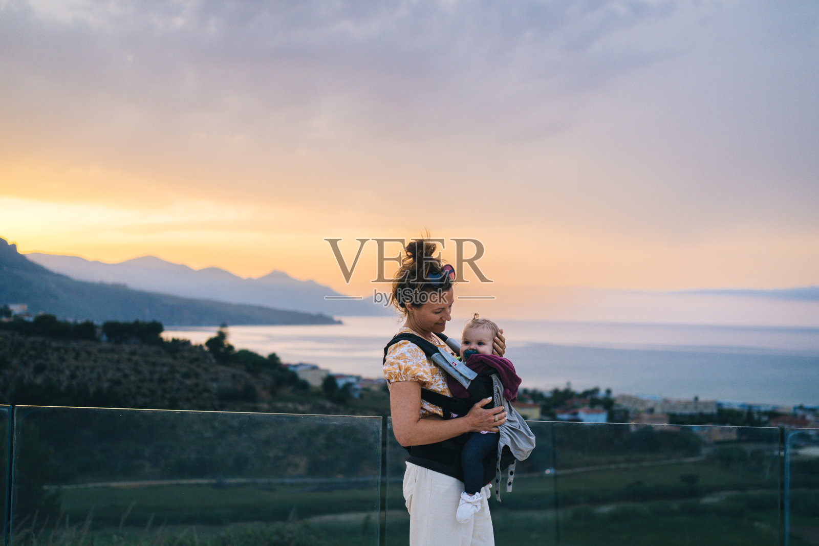 母亲抱着婴儿在游泳池旁照片摄影图片