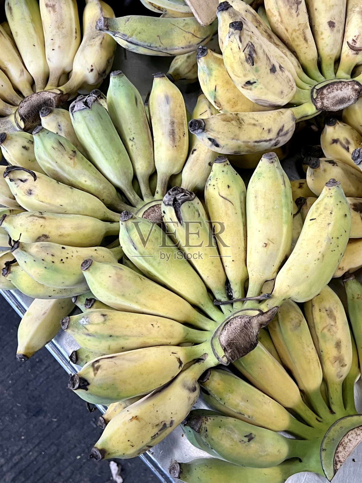 一张桌子上放着一串香蕉的照片,有很多串香蕉在展示照片摄影图片