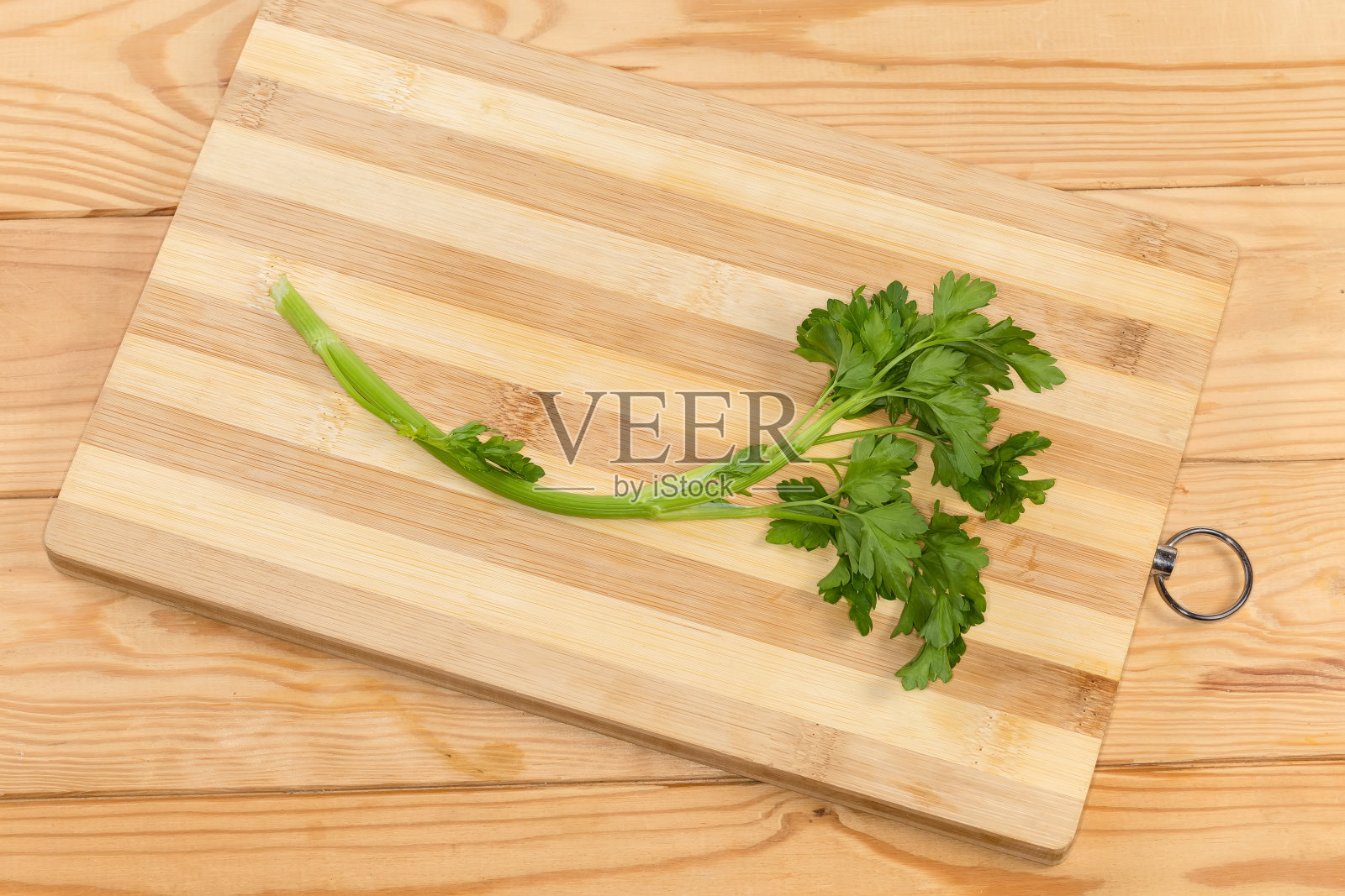 将新鲜欧芹的嫩枝放在砧板上照片摄影图片