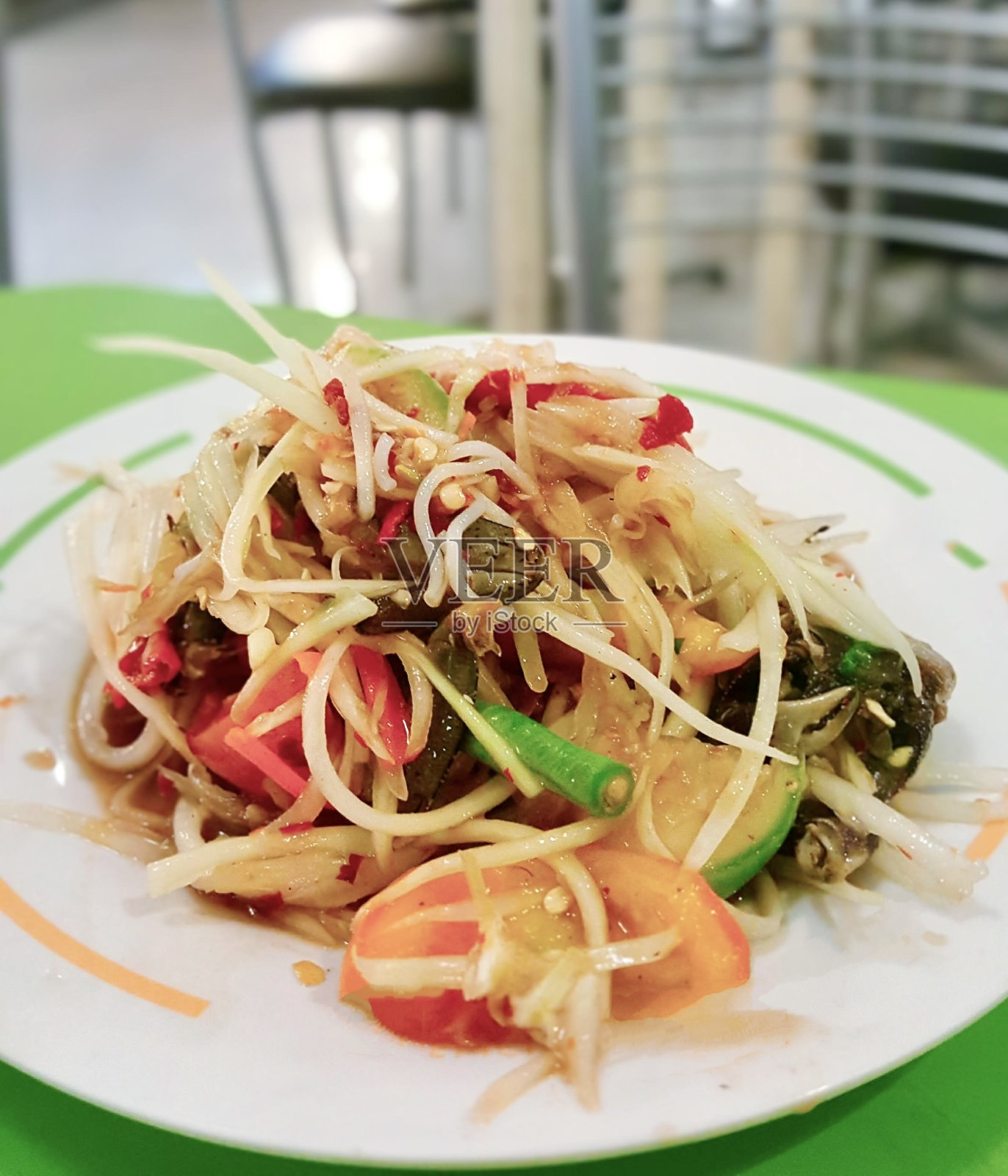 一盘食物放在铺着绿色桌布的桌子上。照片摄影图片