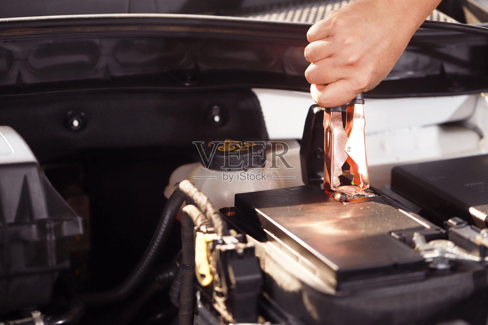 开车前检查汽车蓄电池。照片摄影图片