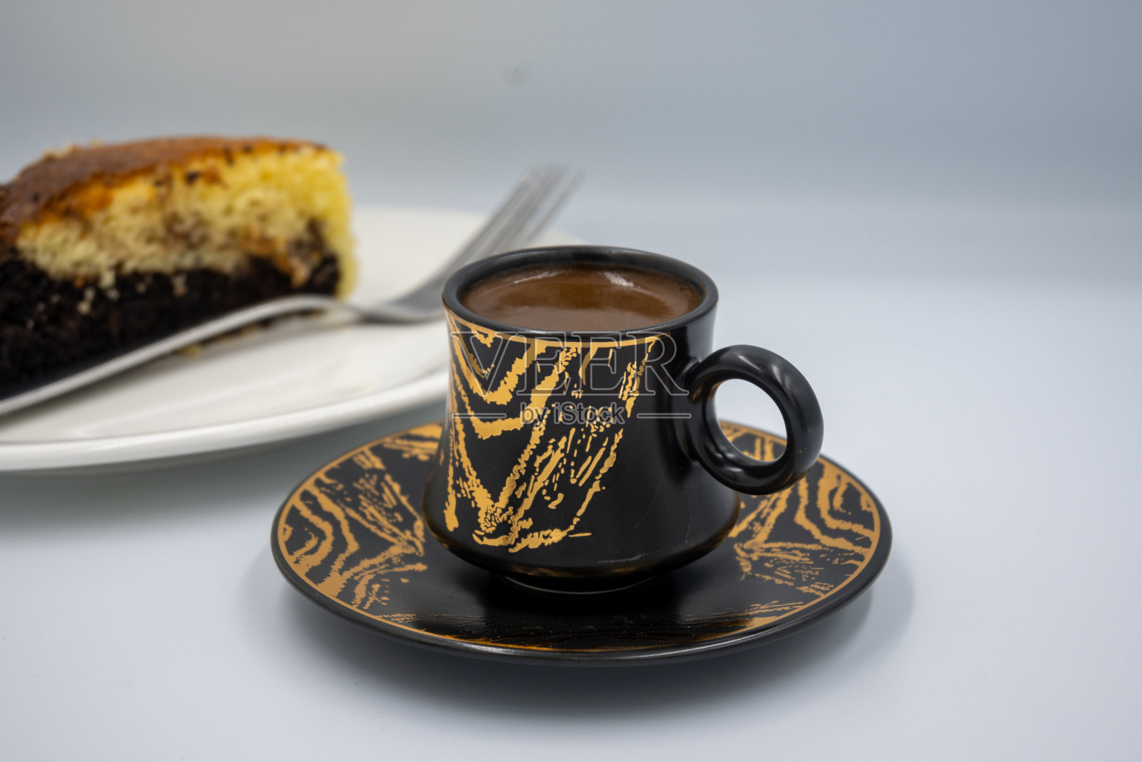 金色线条土耳其咖啡杯和一块蛋糕照片摄影图片