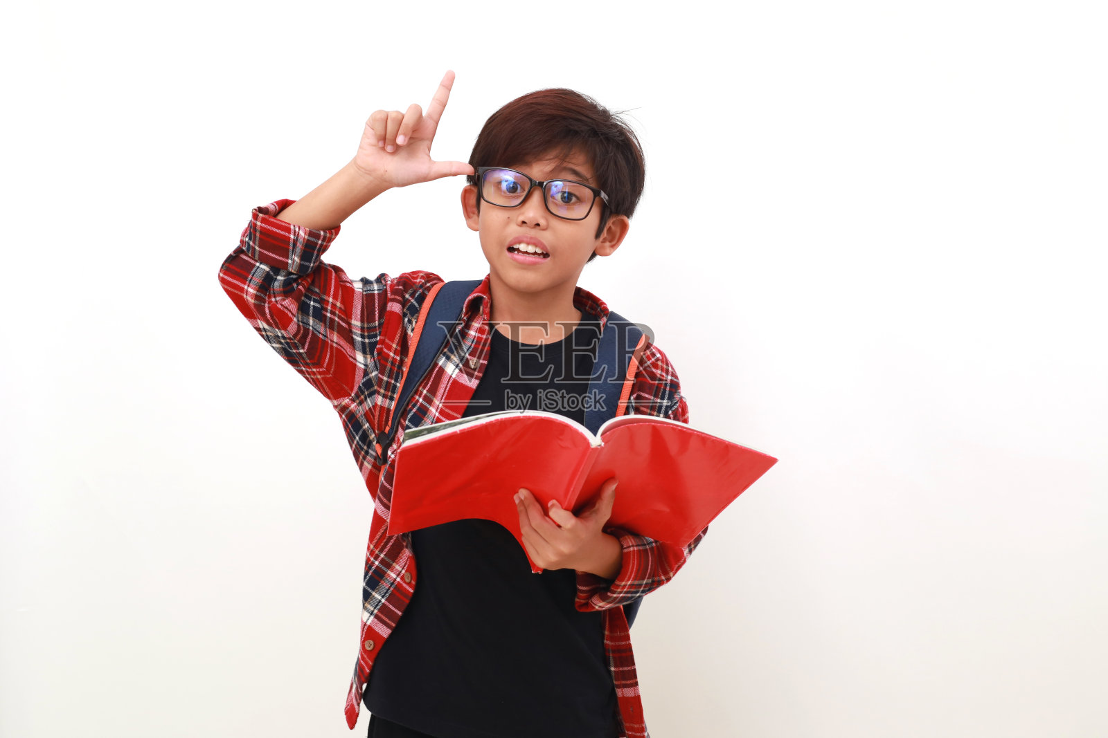 聪明的亚洲学生拿着一本书站着的肖像。孤立于白色照片摄影图片