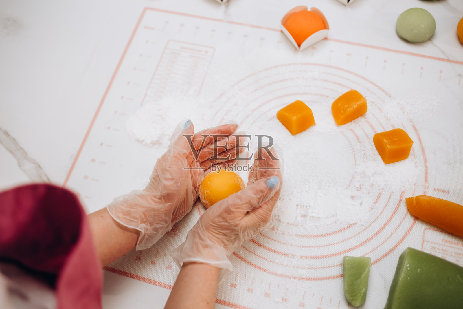 女子正在塑造一块糯米糕,上面撒上淀粉粉,做成甜点照片摄影图片