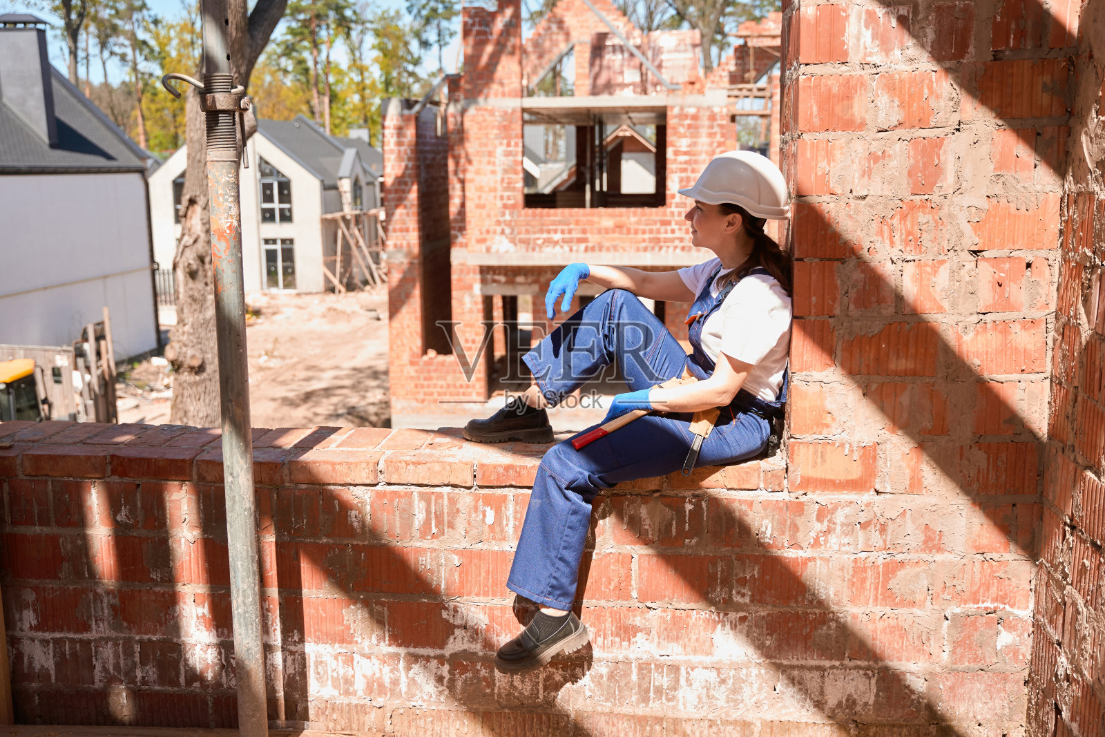 女建筑工程师休息,坐在房子的窗洞里照片摄影图片