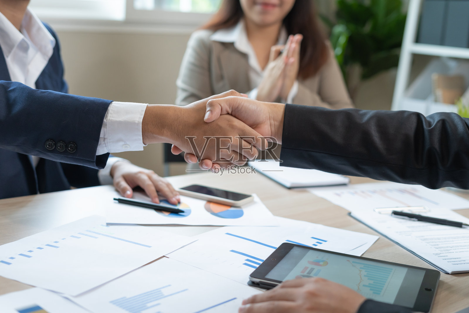 业绩达到目标后,高管们正在握手。财务数据分析和市场增长报告图表。规划策略,启动项目,盈利策略,商务会议时间照片摄影图片