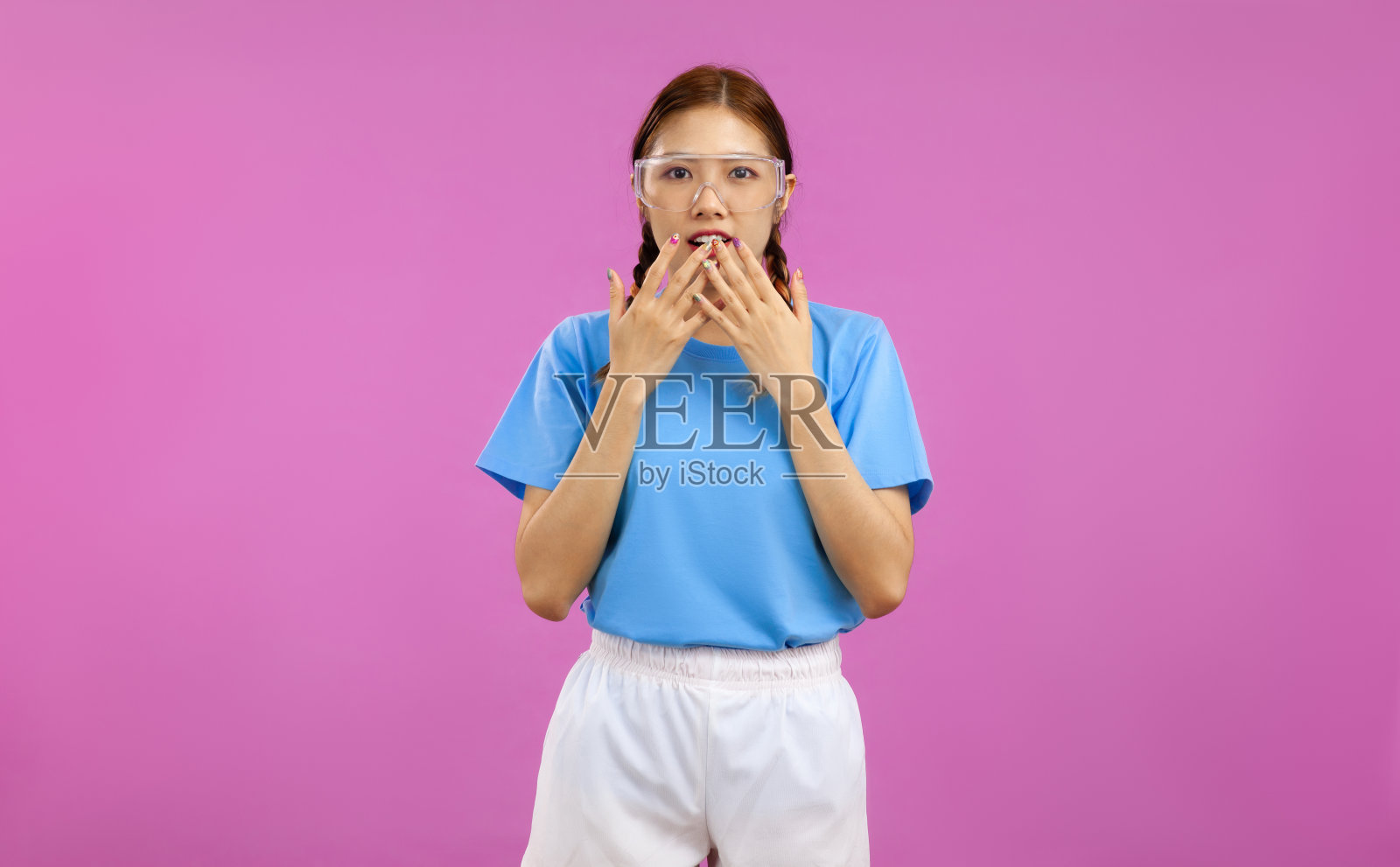 年轻的亚洲女性的肖像看着相机与表情感到惊讶孤立在粉红色的背景,广告推广概念照片摄影图片