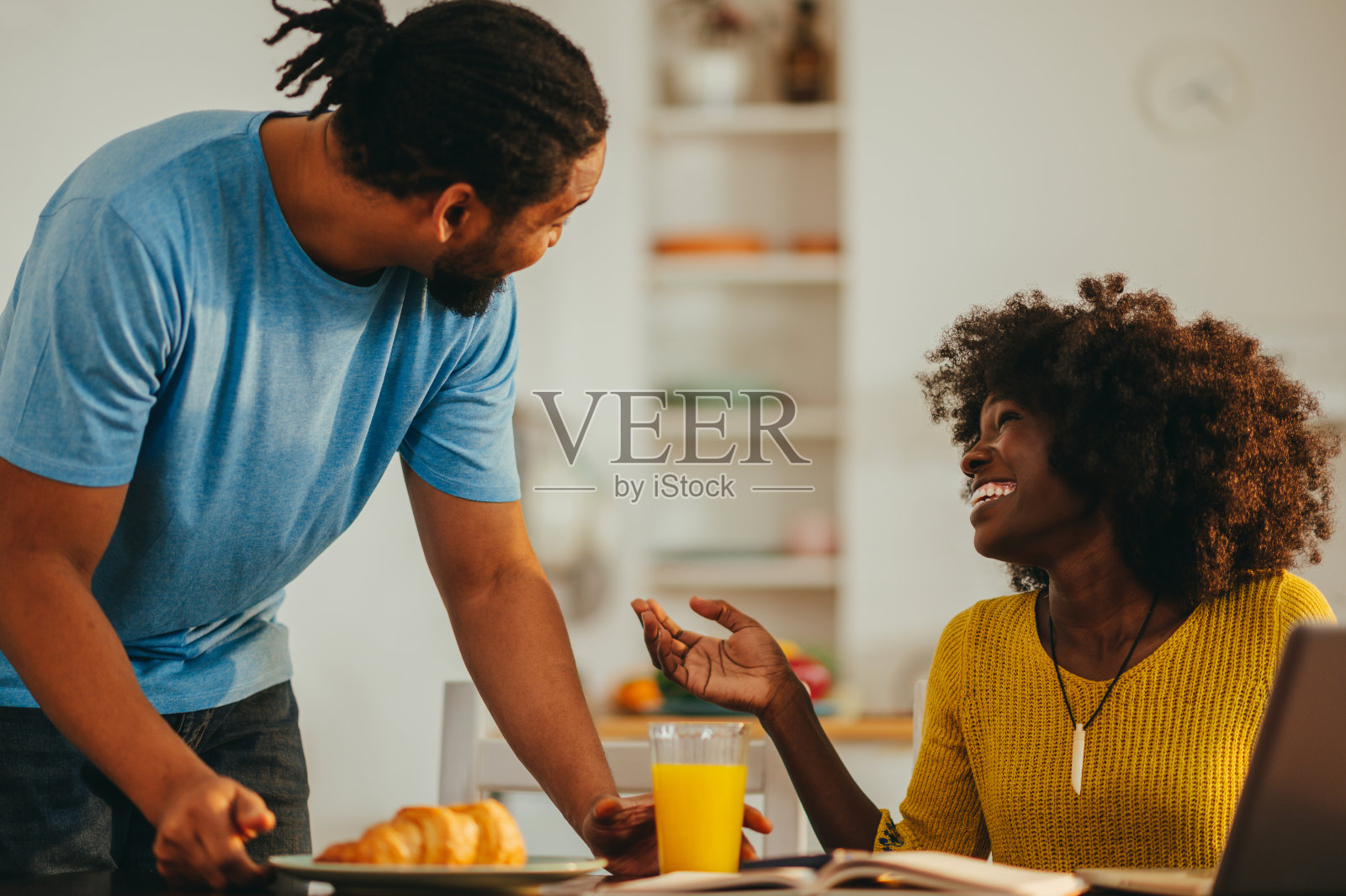 一位体贴的非裔美国丈夫在家里用早餐给他工作的妻子一个惊喜。照片摄影图片
