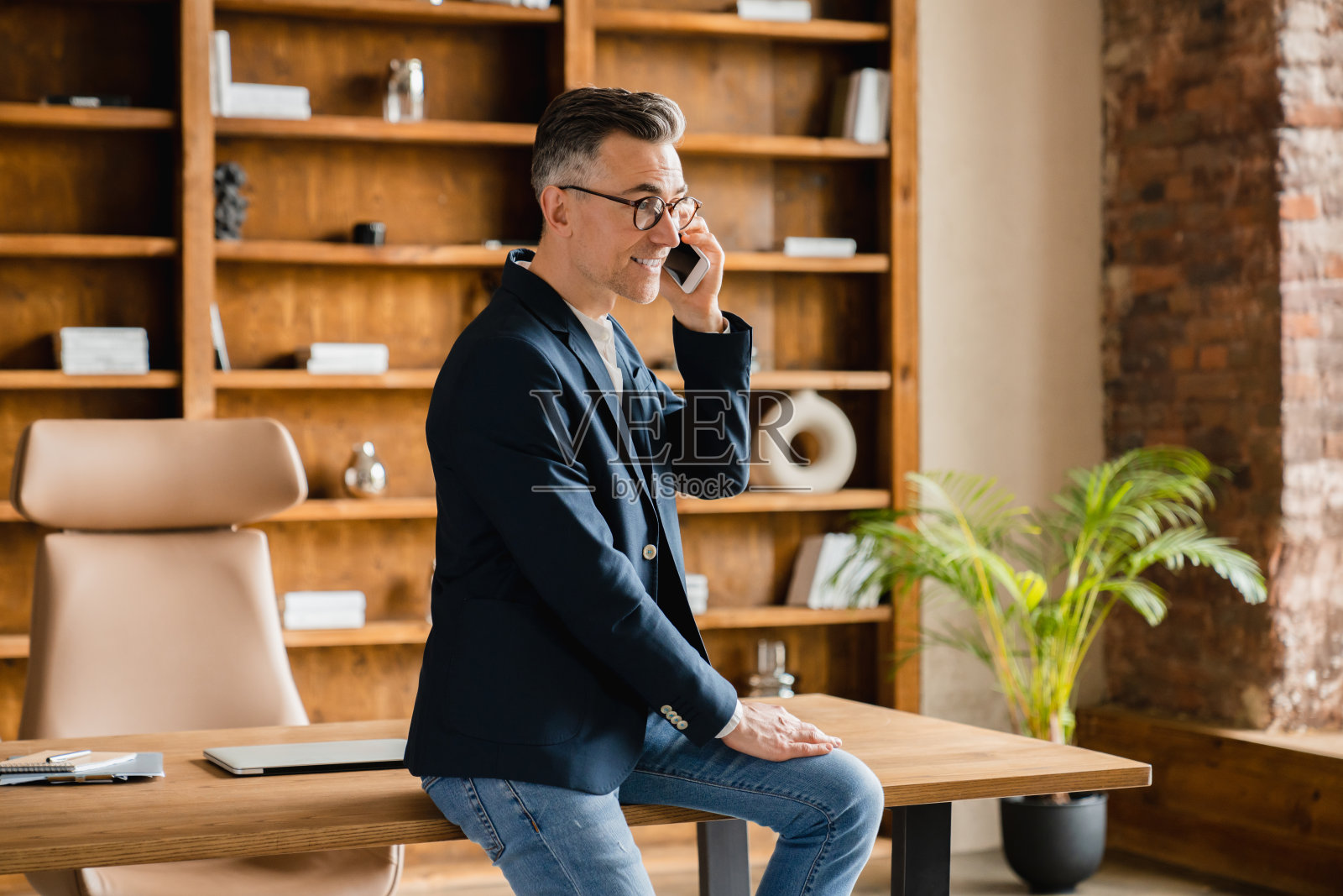 白人,中年,成熟的商人,ceo,老板,自由职业者,在办公室用智能手机与客户聊天,在网上咨询客户照片摄影图片