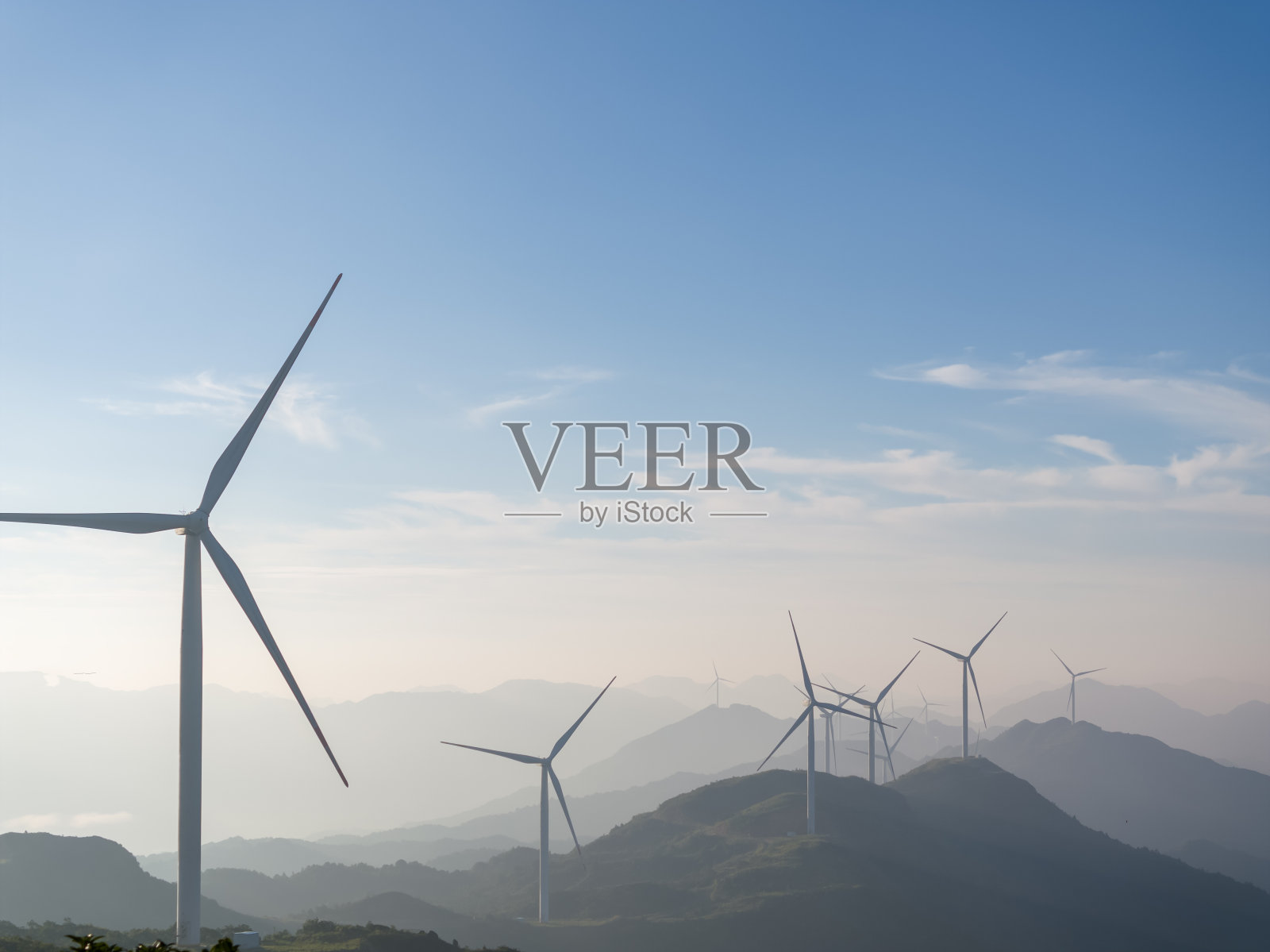 阳光明媚的一天,山顶上的风力涡轮机照片摄影图片