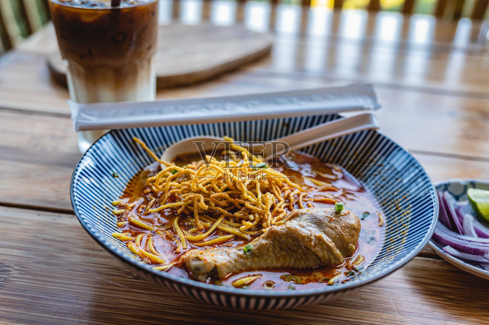 近距离观看配以鸡腿和炸粉丝的烧面。照片摄影图片