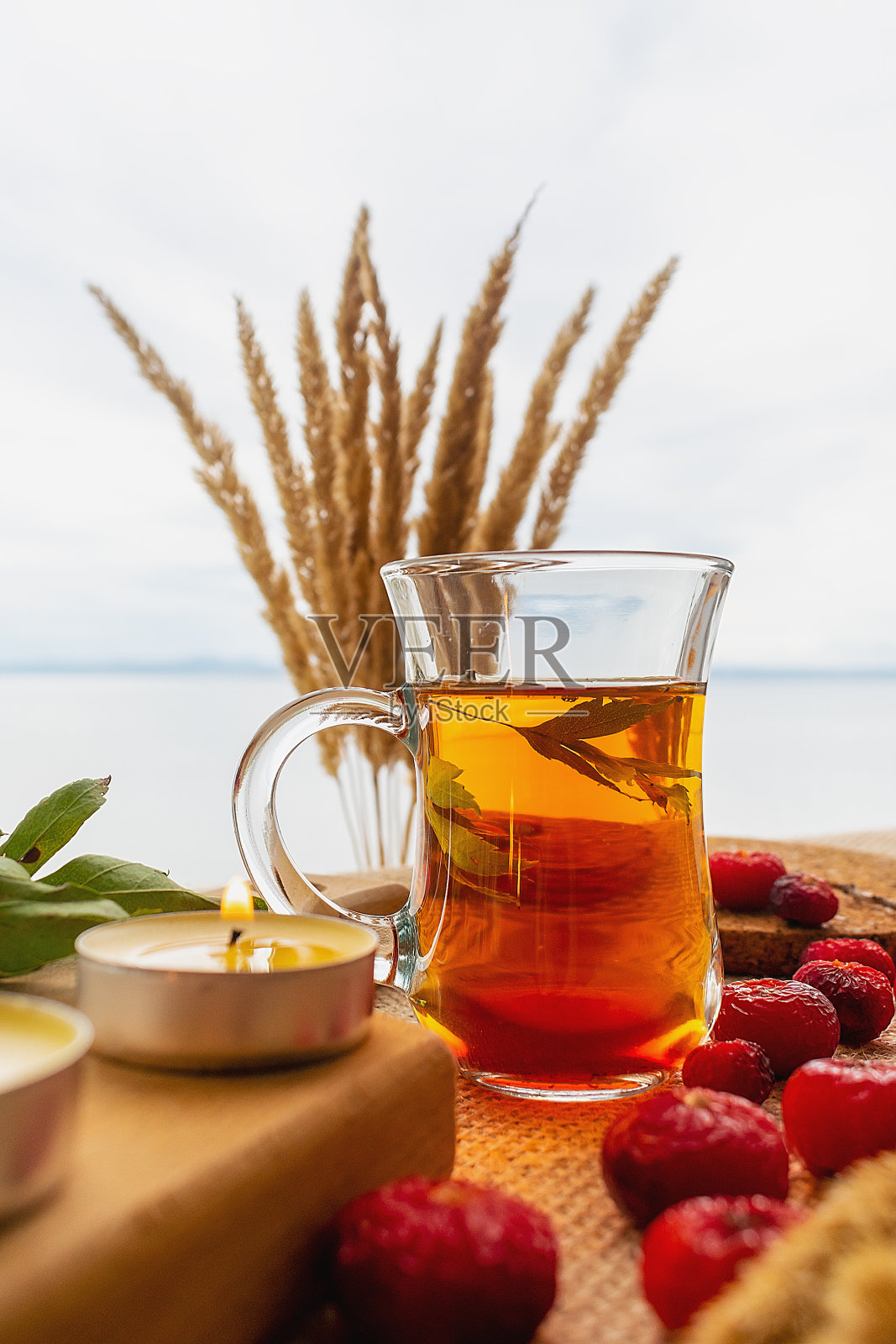 在多云天空的背景下,红茶和玫瑰果照片摄影图片