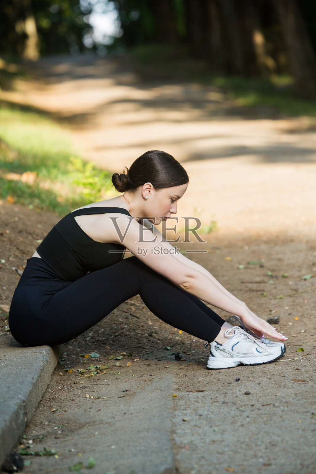 穿着黑色运动服在户外运动的年轻女子。照片摄影图片