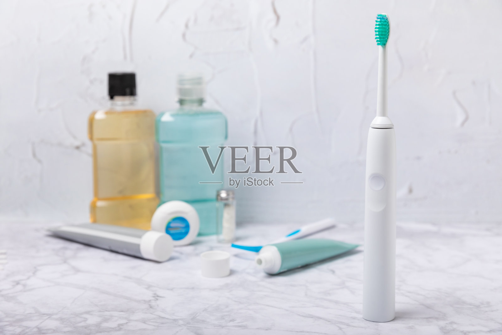 电子超声波牙刷,漱口水,牙线,洁舌器和牙膏纹理背景。浴室里的牙齿护理和预防龋齿用品。牙科的概念。复制spac照片摄影图片