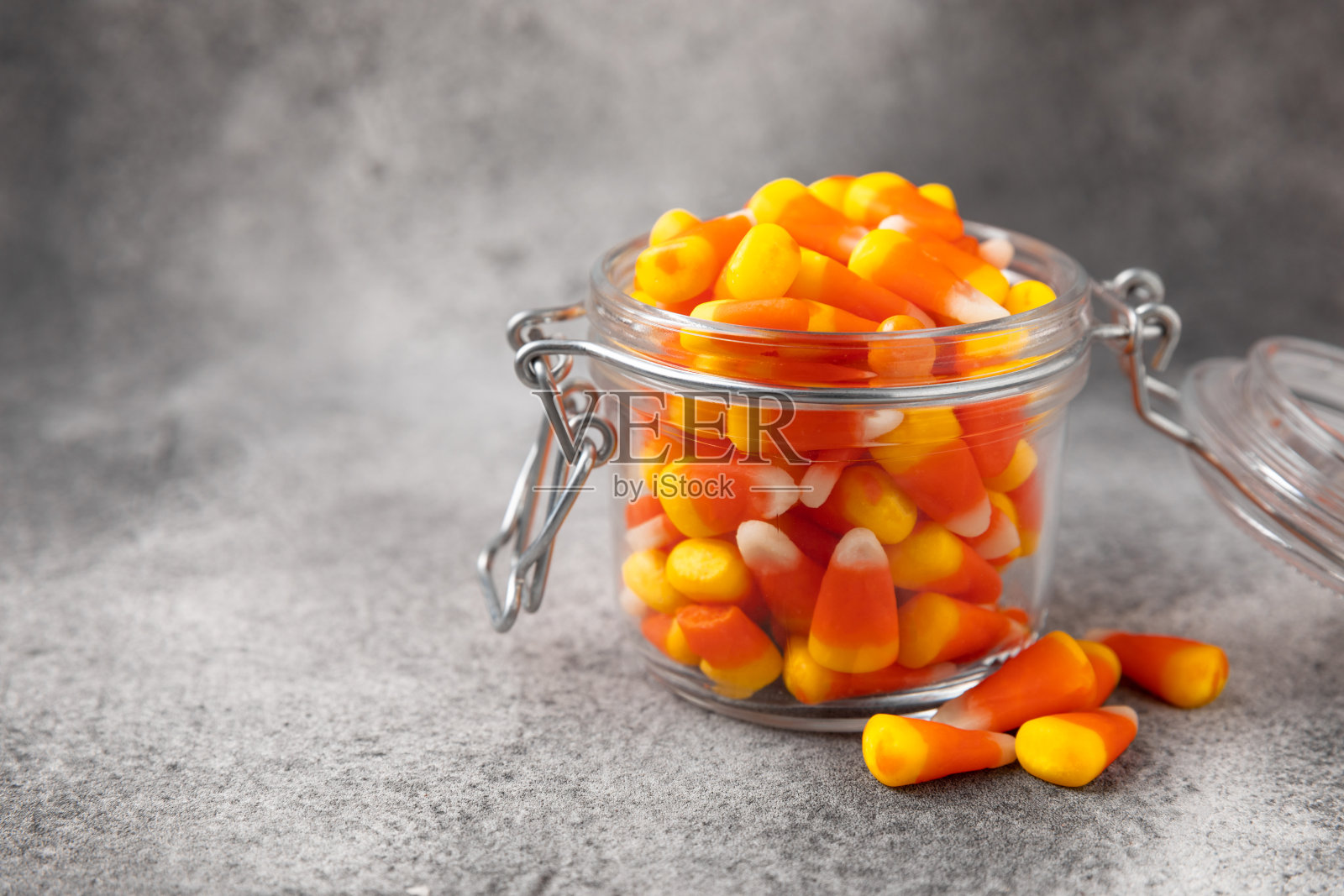 黑色背景的万圣节糖果。咖啡玉米和沙扎头骨。万圣节的节日背景有南瓜南瓜灯、玉米糖和装饰品。前视图。平的。放文字的地方。照片摄影图片