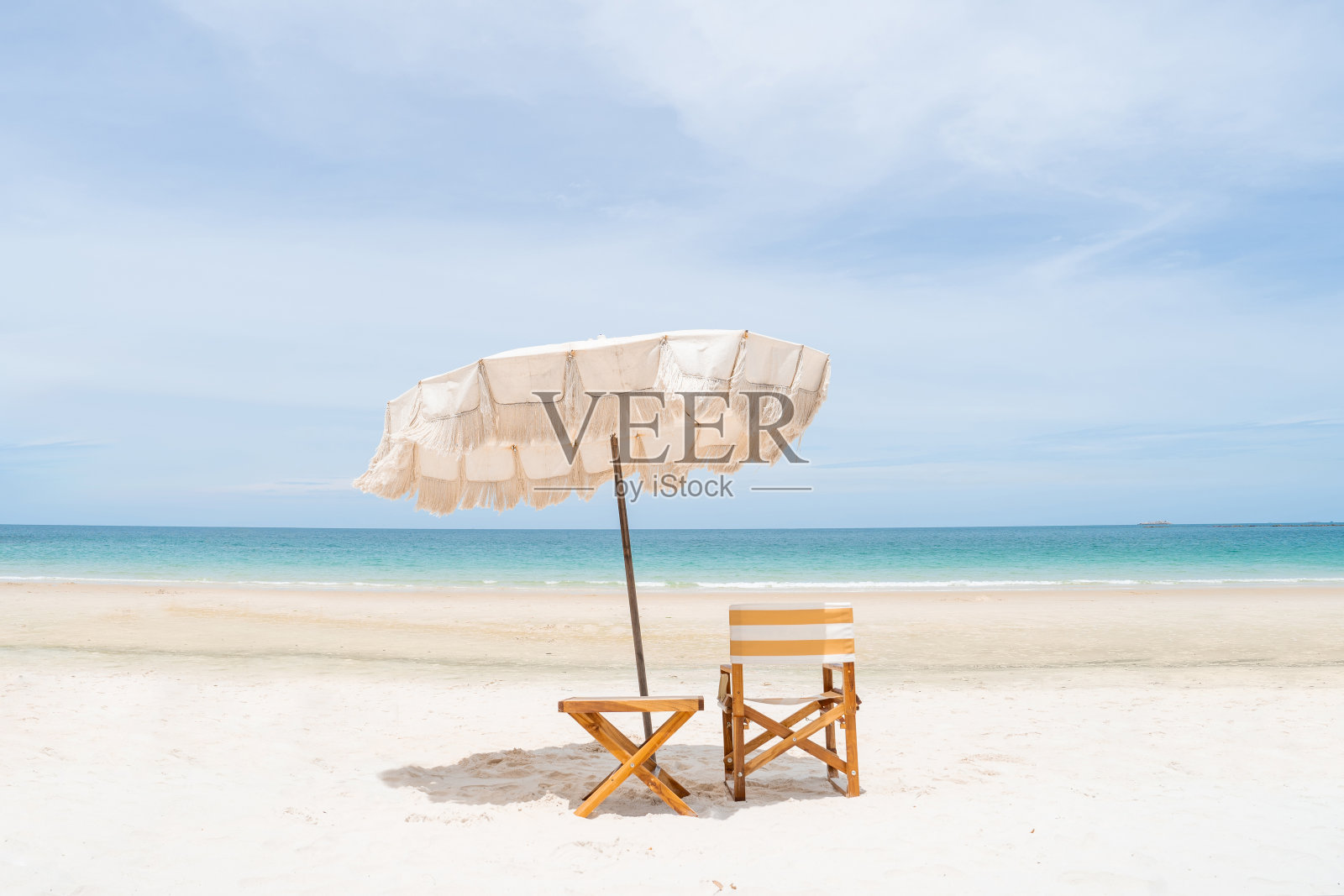 沙滩伞和沙滩椅,白色的沙滩和完美的蓝天。照片摄影图片