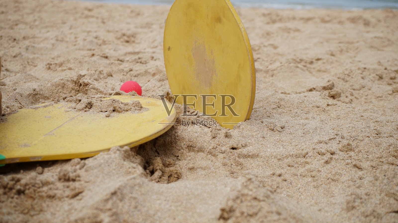 沙滩上的球拍和木球。照片摄影图片