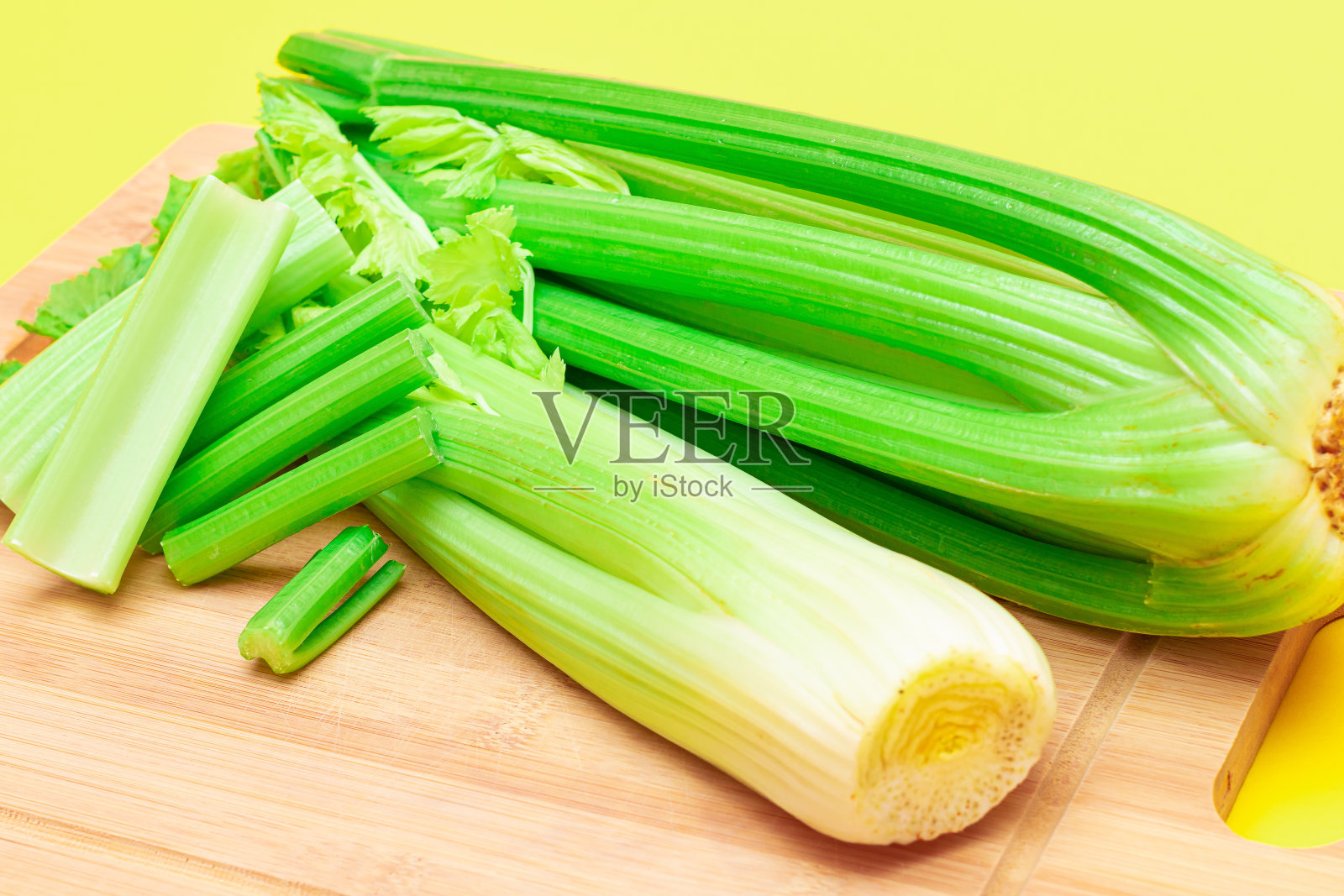 鲜芹菜茎和芹菜碎放在砧板上照片摄影图片