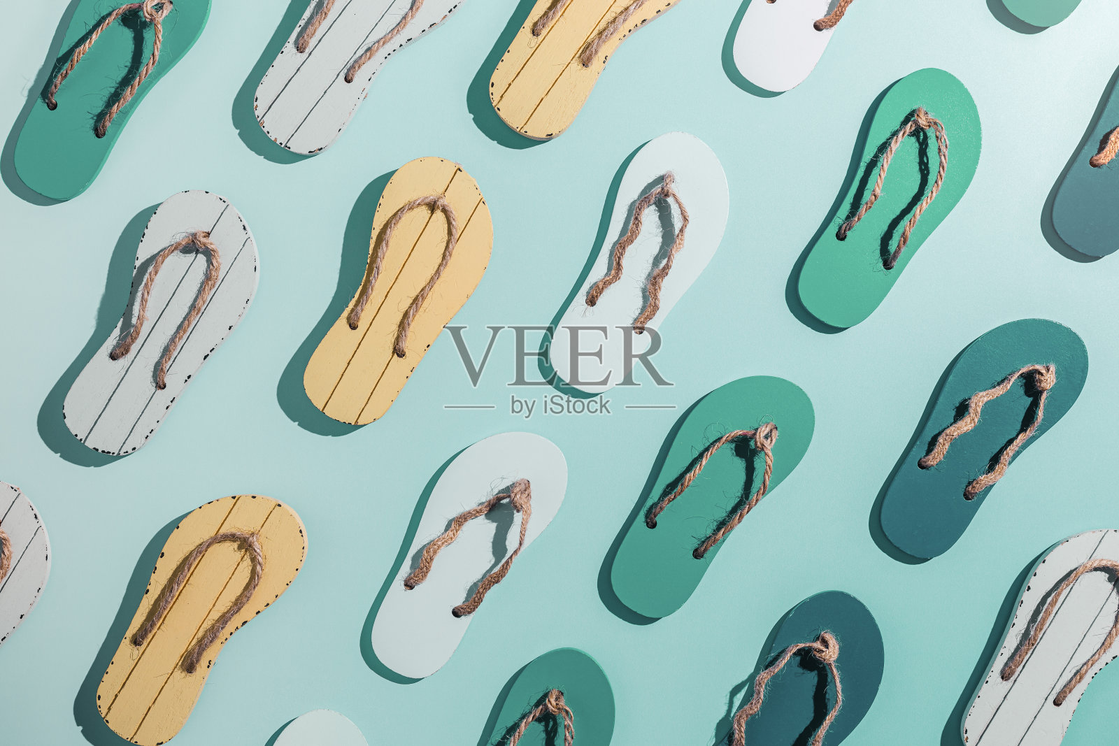 女夏季鞋凉鞋作为创意极简图案与硬阴影,蓝绿色渐变色背景上的黄色人字拖。审美潮流夏日时尚理念,生活格调照片摄影图片