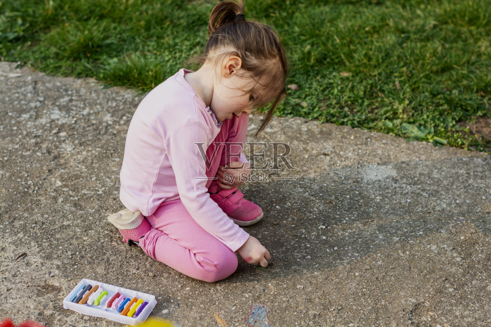 孩子在院子里用粉笔画画照片摄影图片