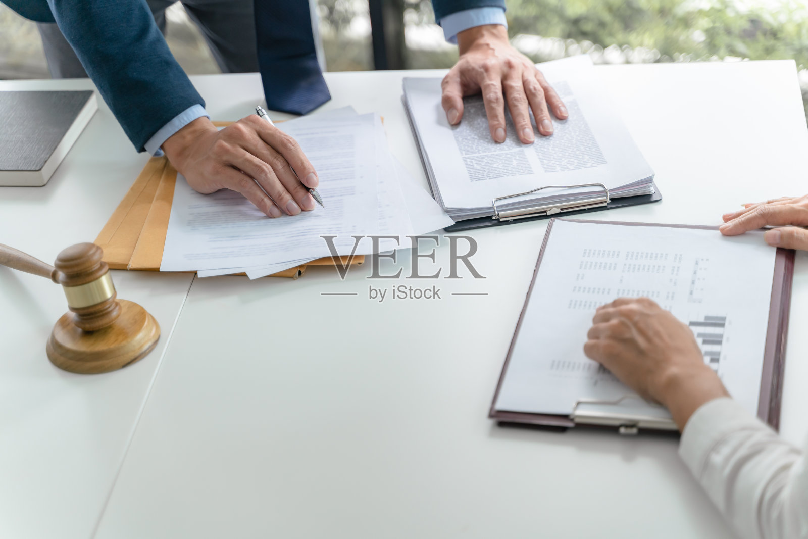 法律顾问向客户展示签署的合同与法槌和法律。司法与律师概念照片摄影图片