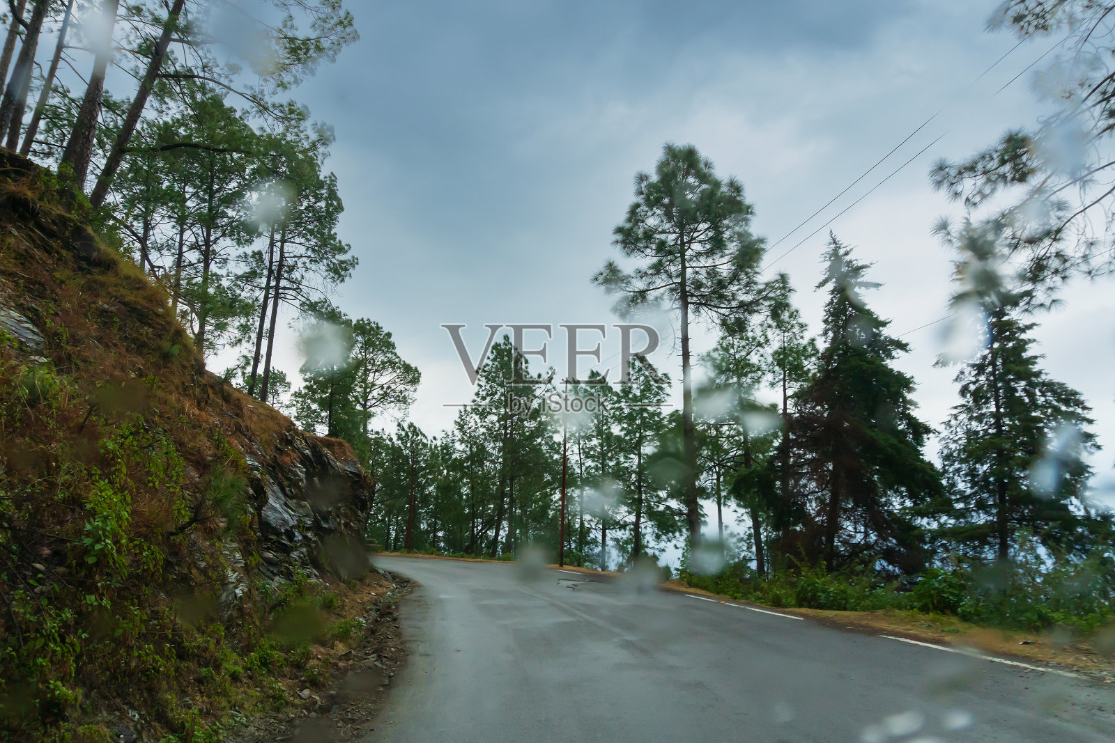 多云的天空和喜马拉雅公路的曲线,季风景观加尔瓦尔,北阿坎德邦,印度。气候变化对喜马拉雅山脉的影响带来了山体滑坡、不适时降雨和山区环境的破坏。照片摄影图片